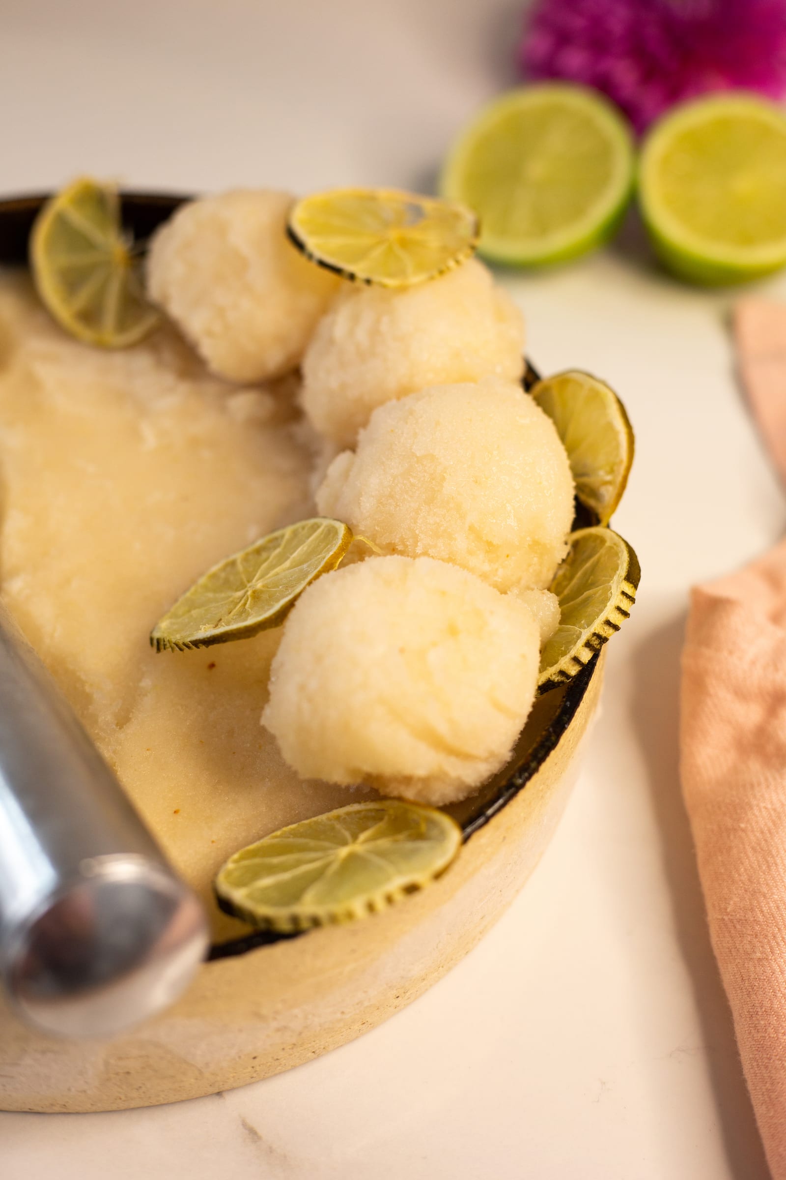 Close-up of the tin of litchi and lemon sorbet scoops with the metal scoop