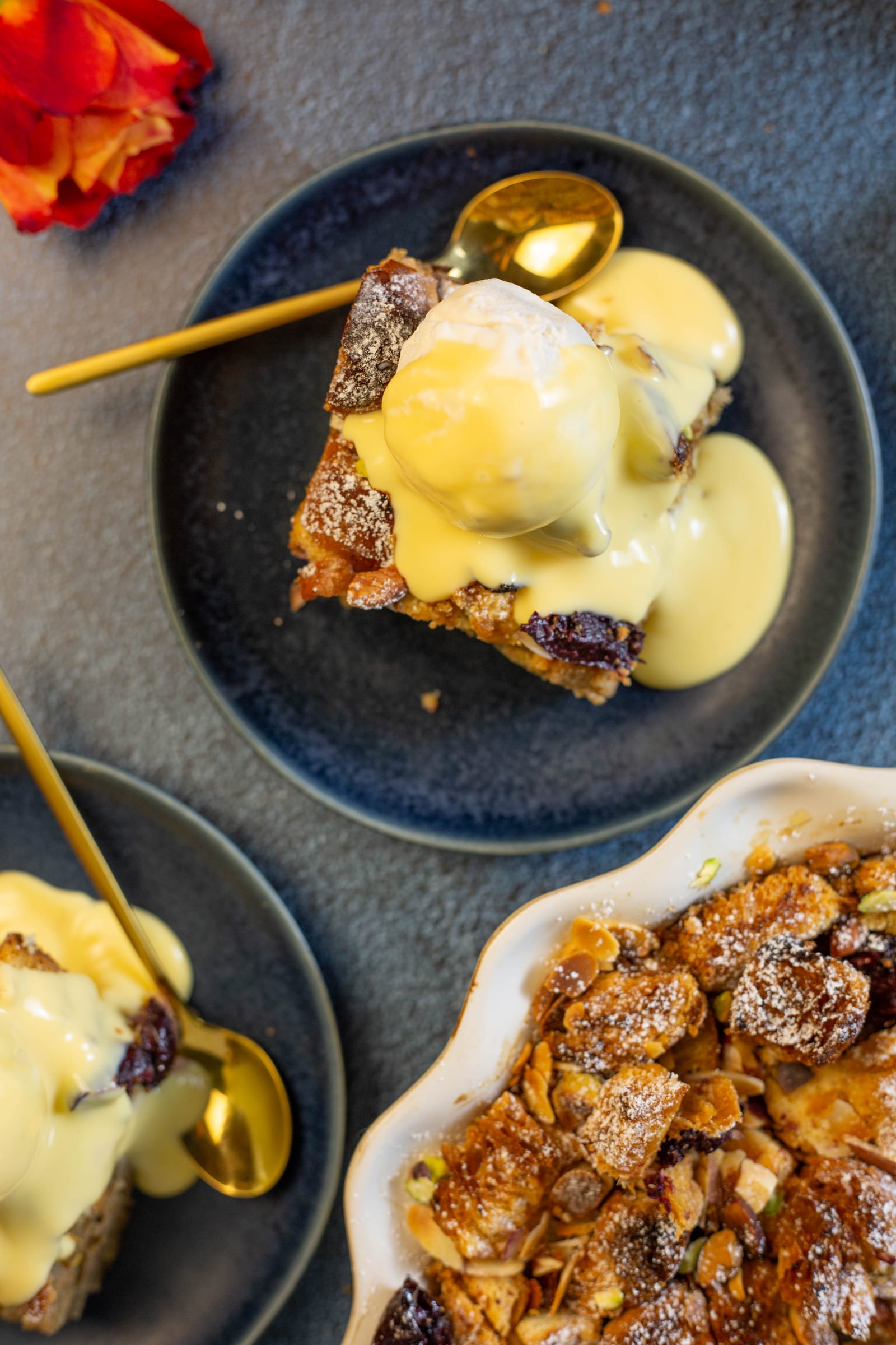 Servings of pudding with custard beside the dish, from above