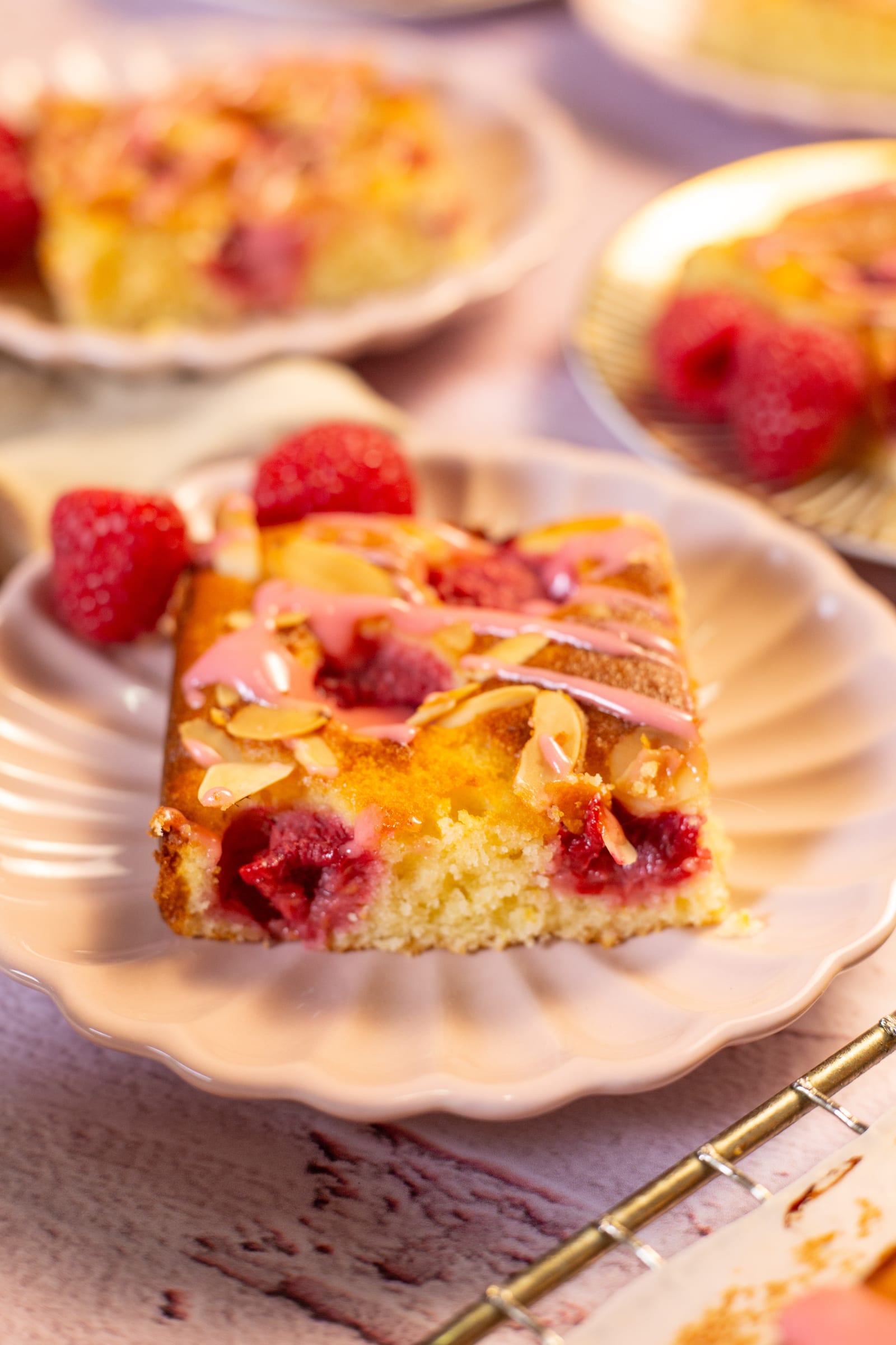 A slice of snack cake with fresh raspberries
