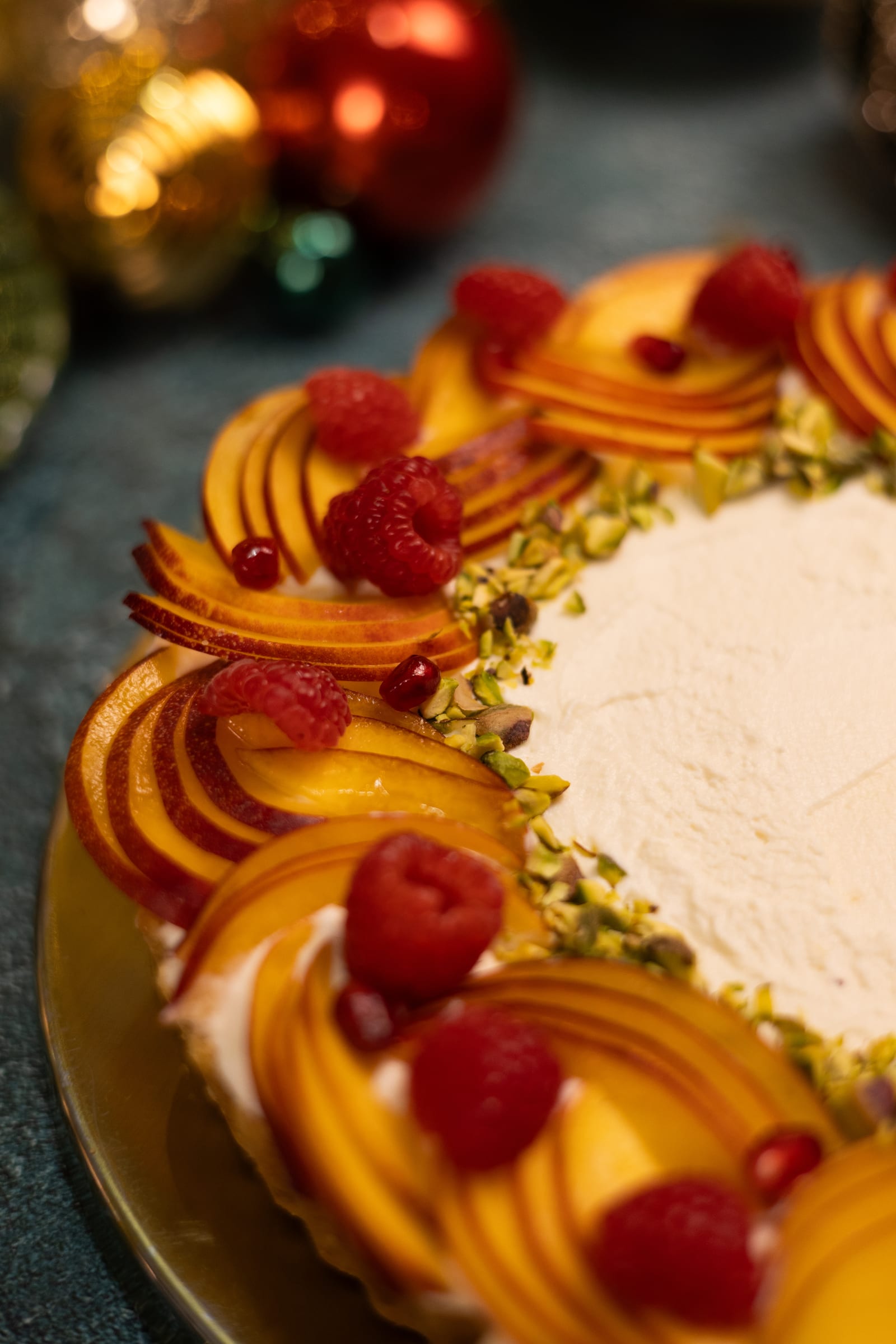 Close-up of nectarine slices, raspberries and pistachios on the tart