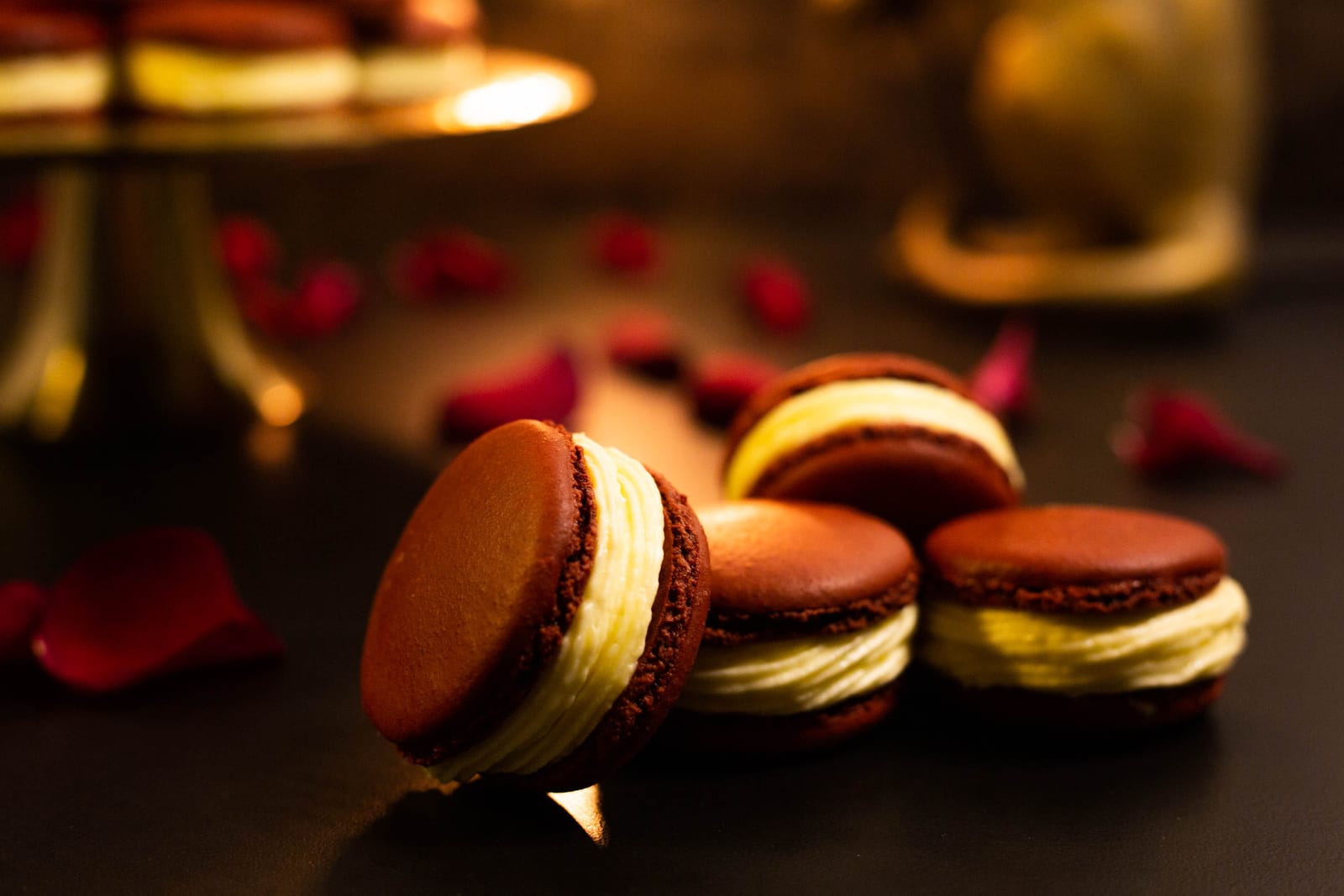 Red velvet macarons in front of a gold stand of macarons