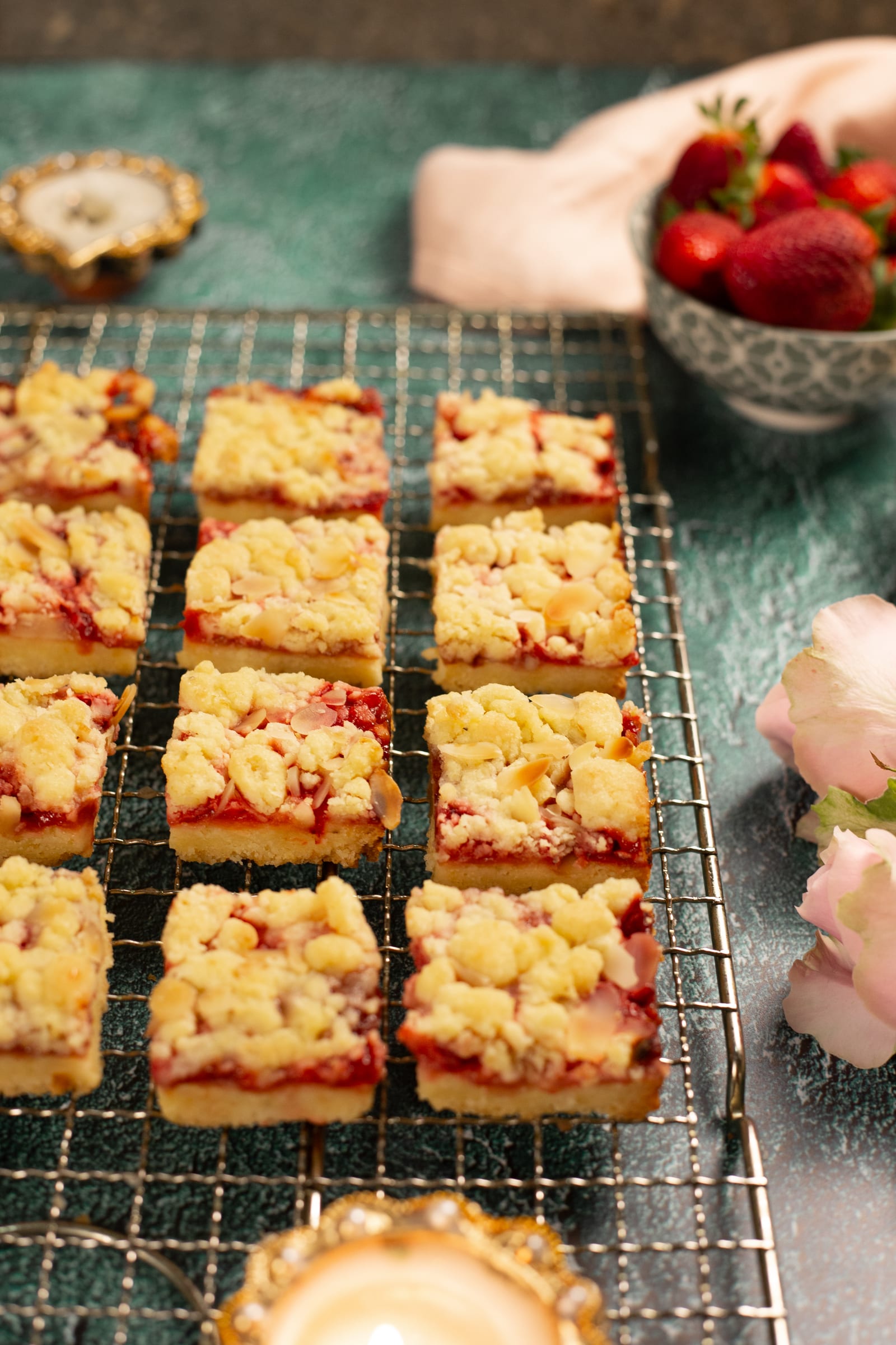 Hungarian tart squares on a wire rack, with a bowl of strawberries