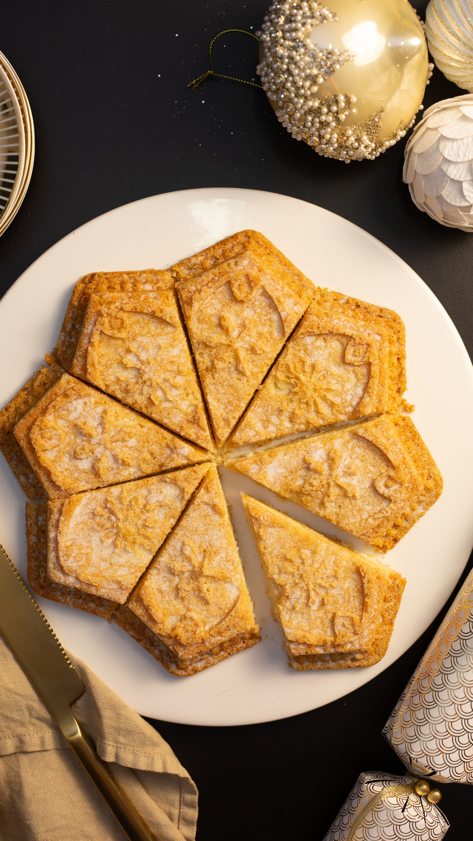Star-shaped shortbread on a white plate, with a wedge pulled away