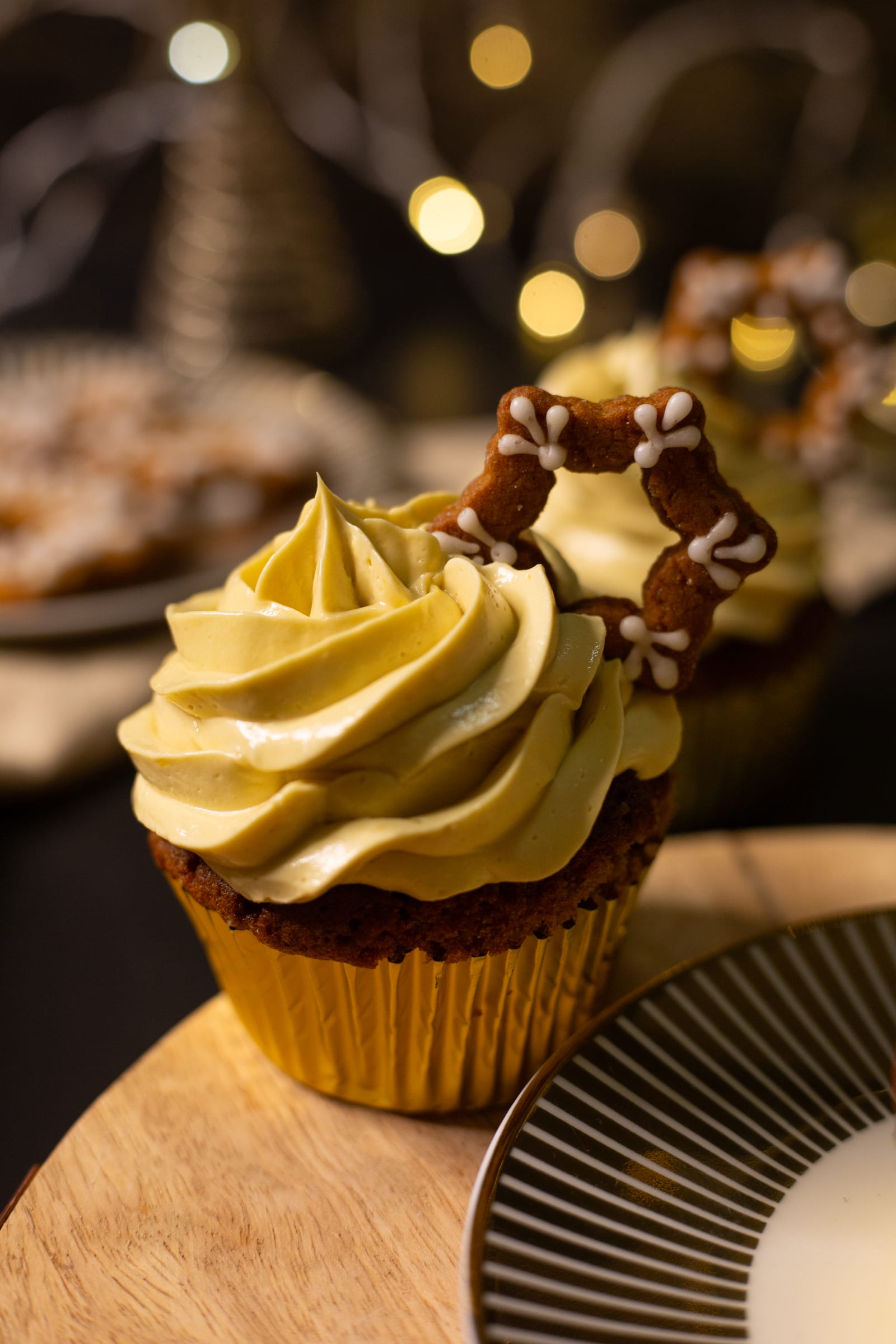 Close-up of a gingerbread cupcake with eggnog buttercream on a wooden board