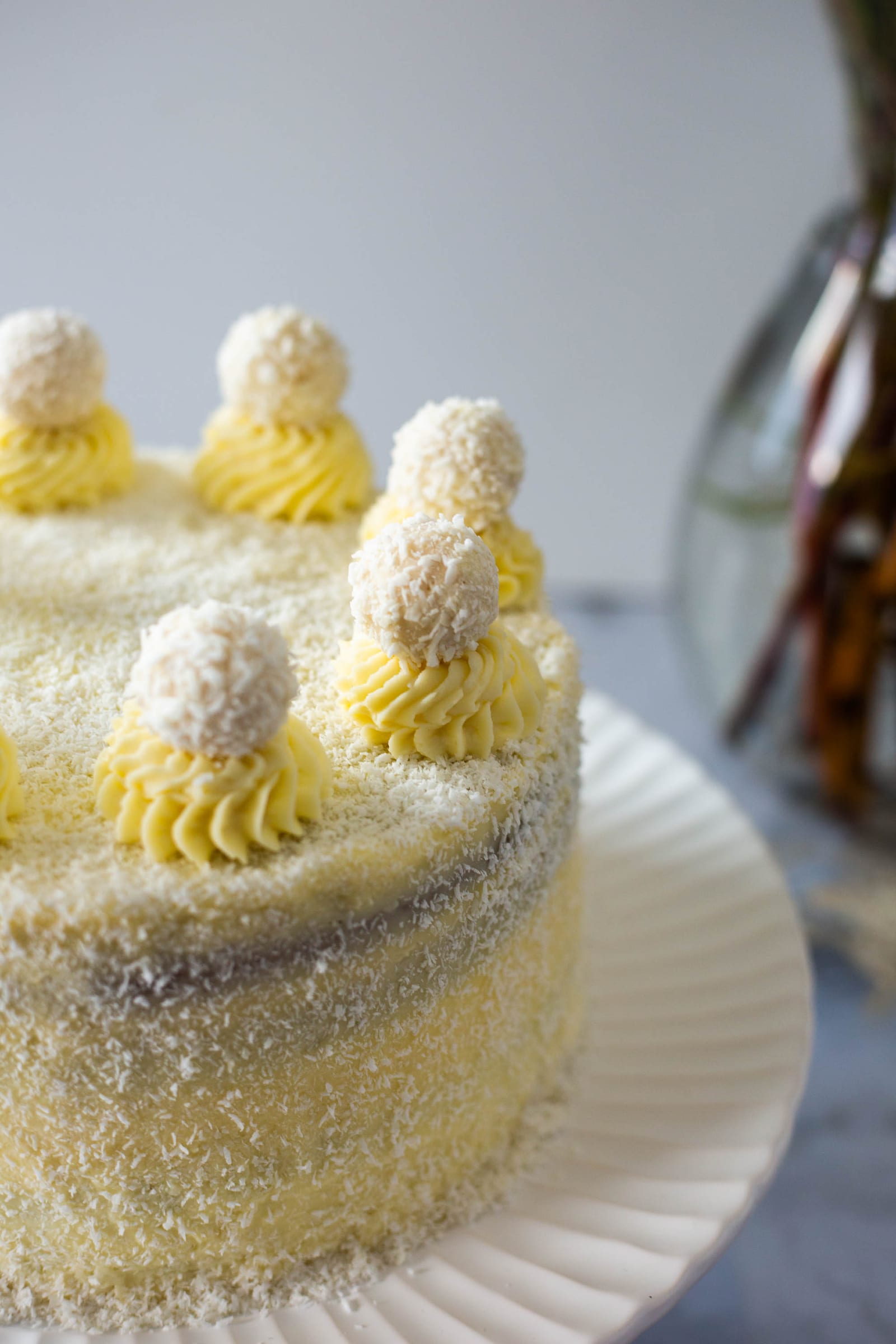 Close-up of the coconut, piped rosettes and coconut balls on a Raffaello cake