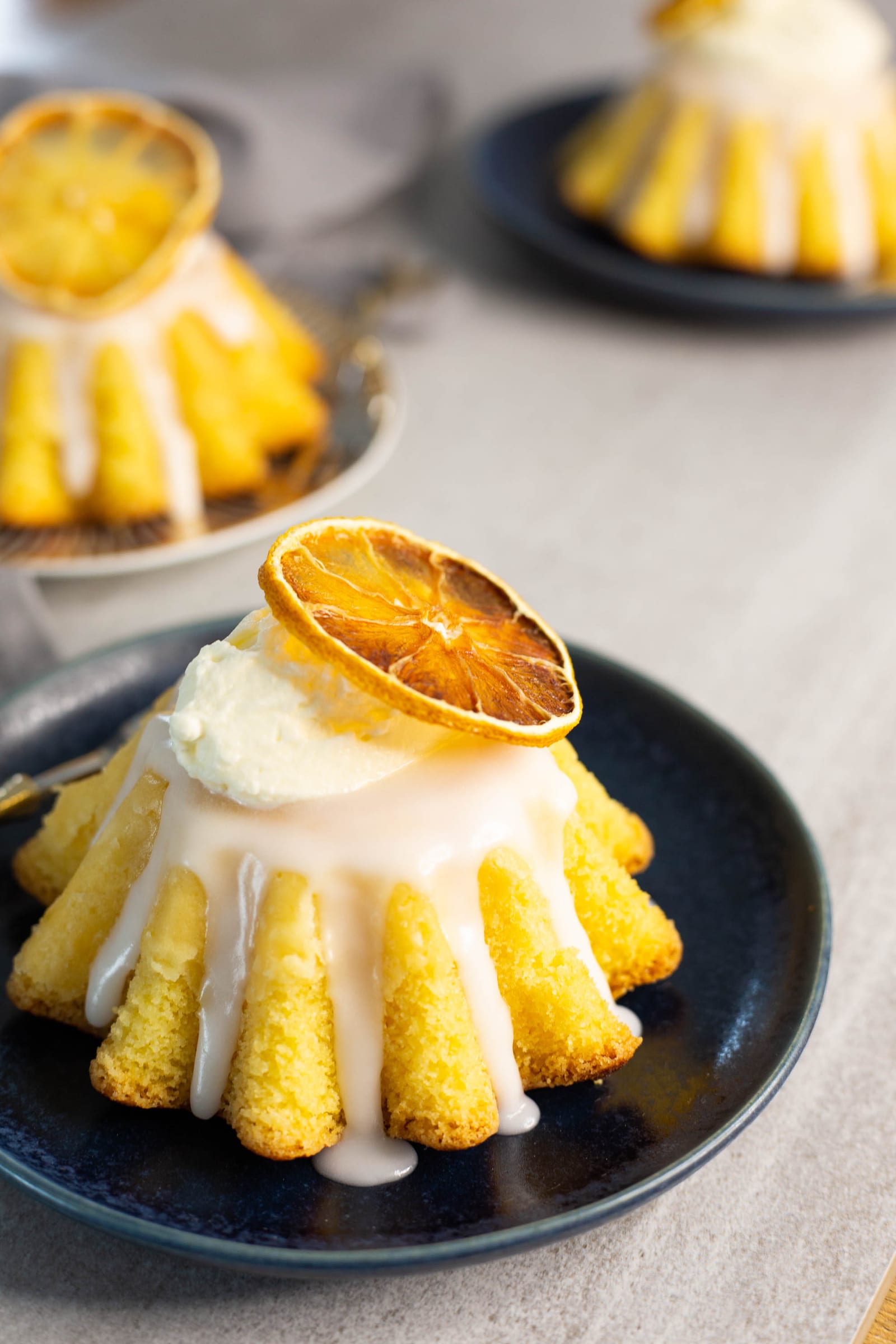 Close-up of lemon glaze dripping down a brioche-shaped mini cake