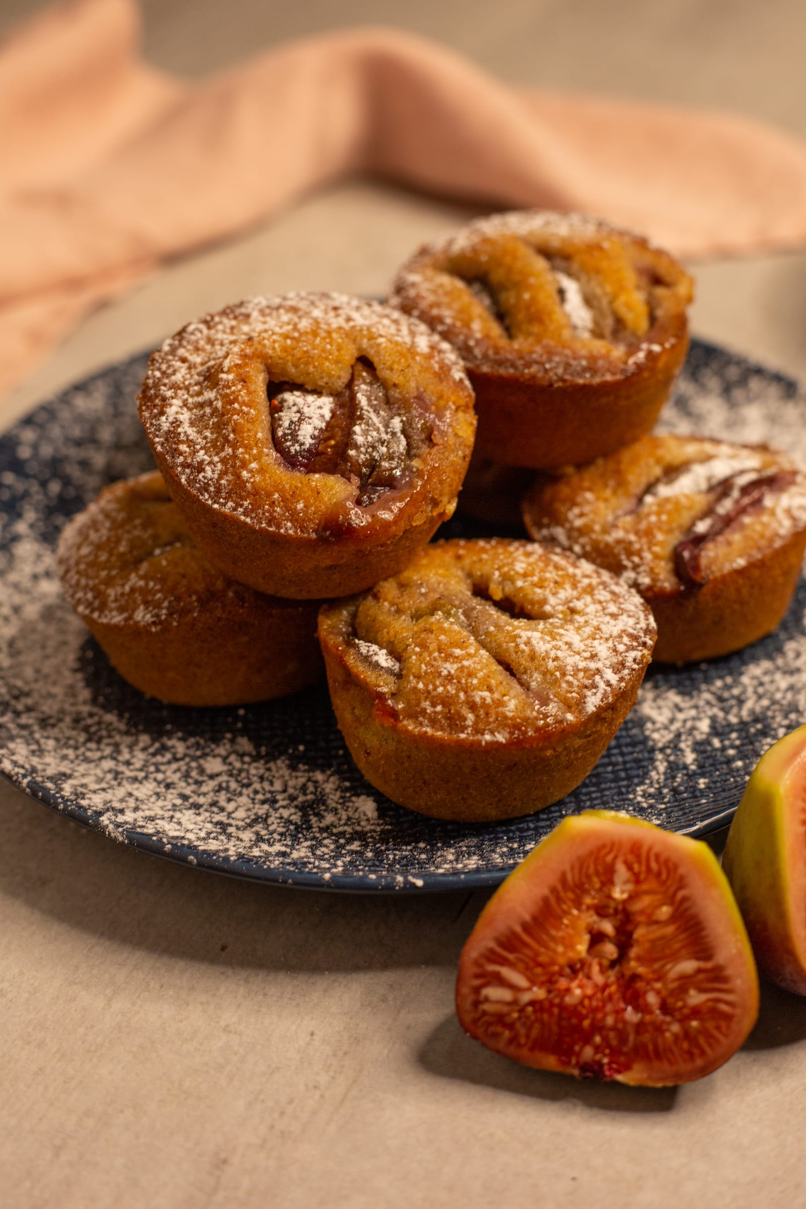 A pile of fig and hazelnut friands with fresh fig halves