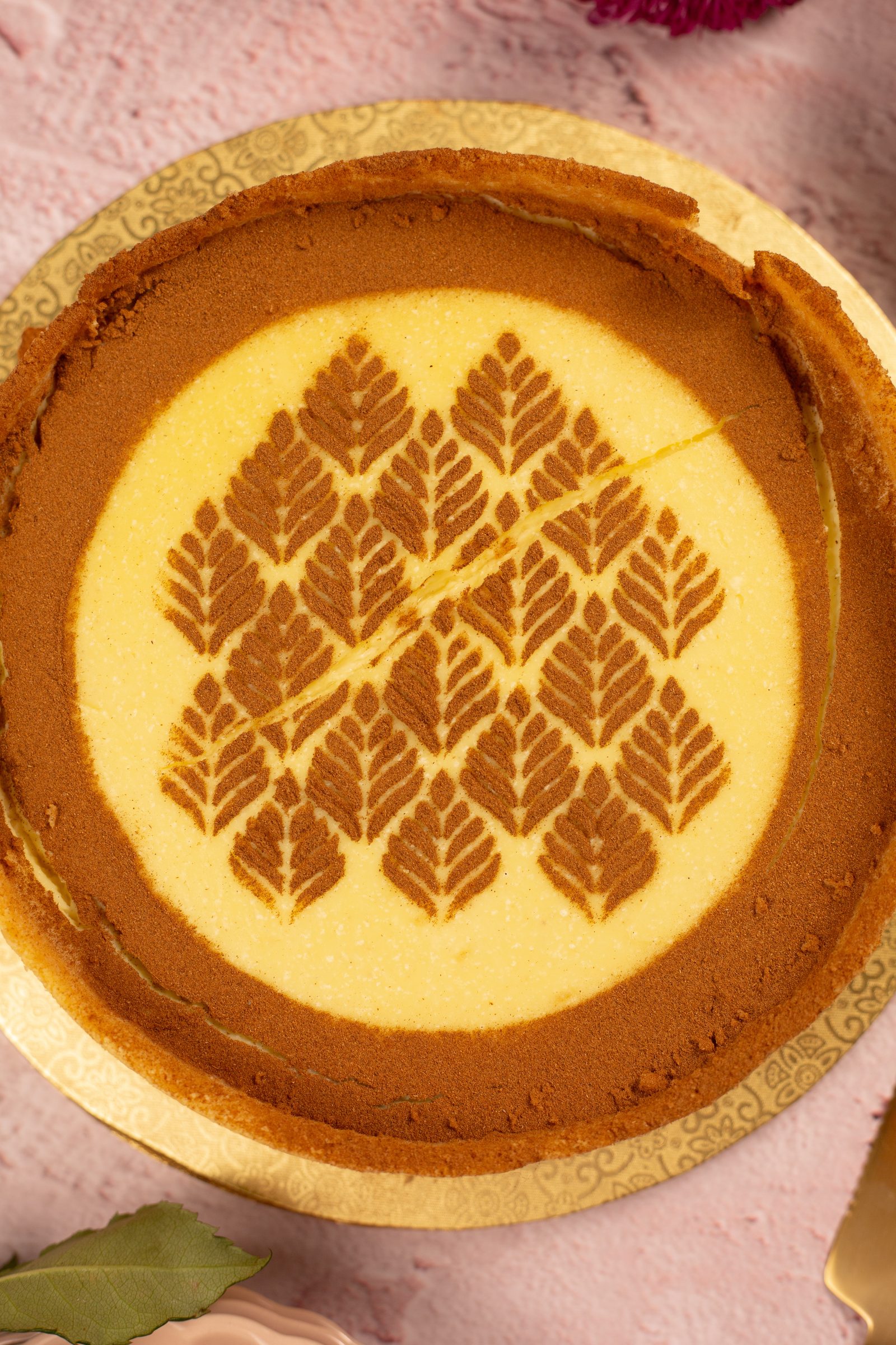 The cinnamon leaf stencil on a no bake milk tart from above, ringed by a band of cinnamon