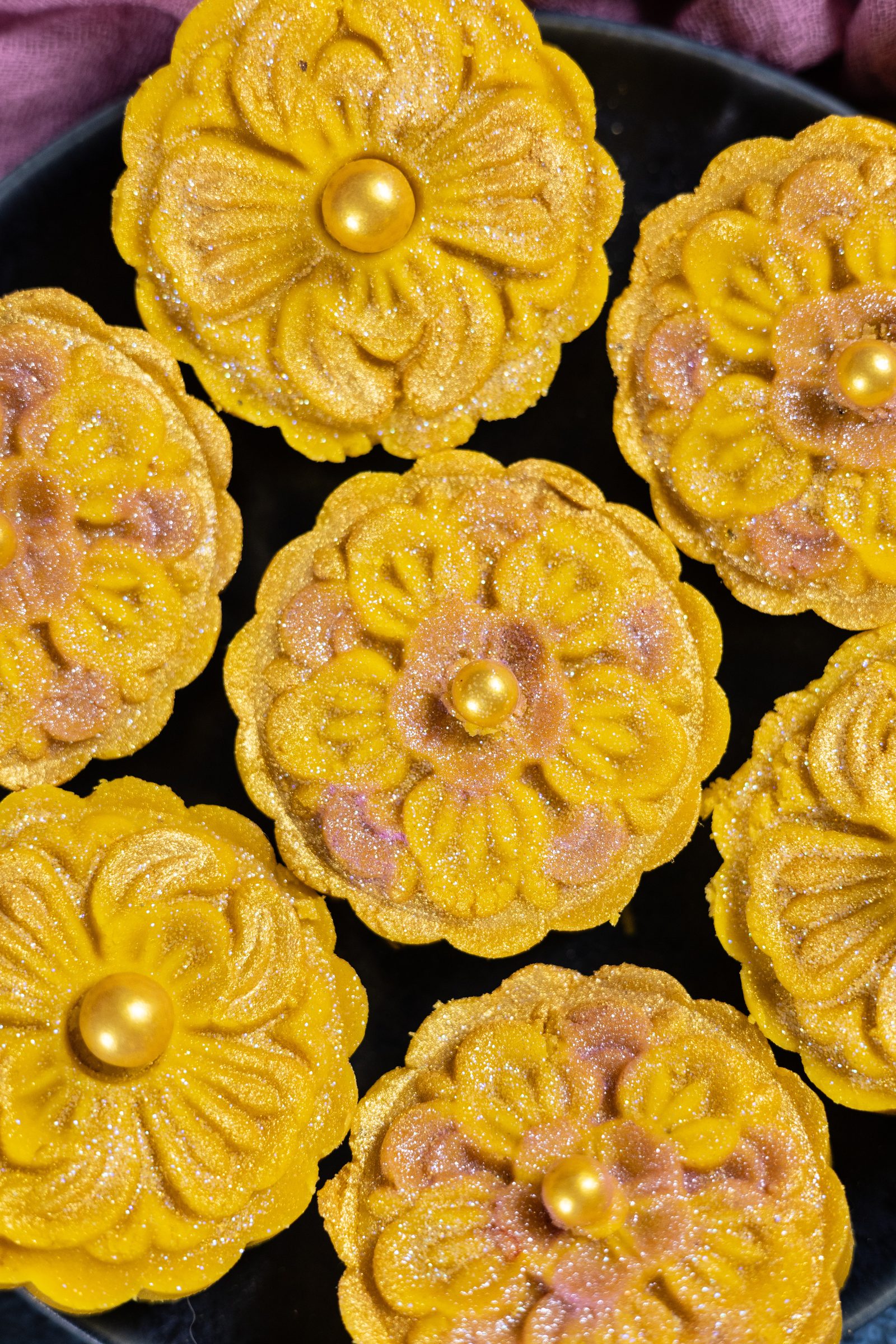Close-up of the flower pattern on mango burfee, dusted with shimmer, from above