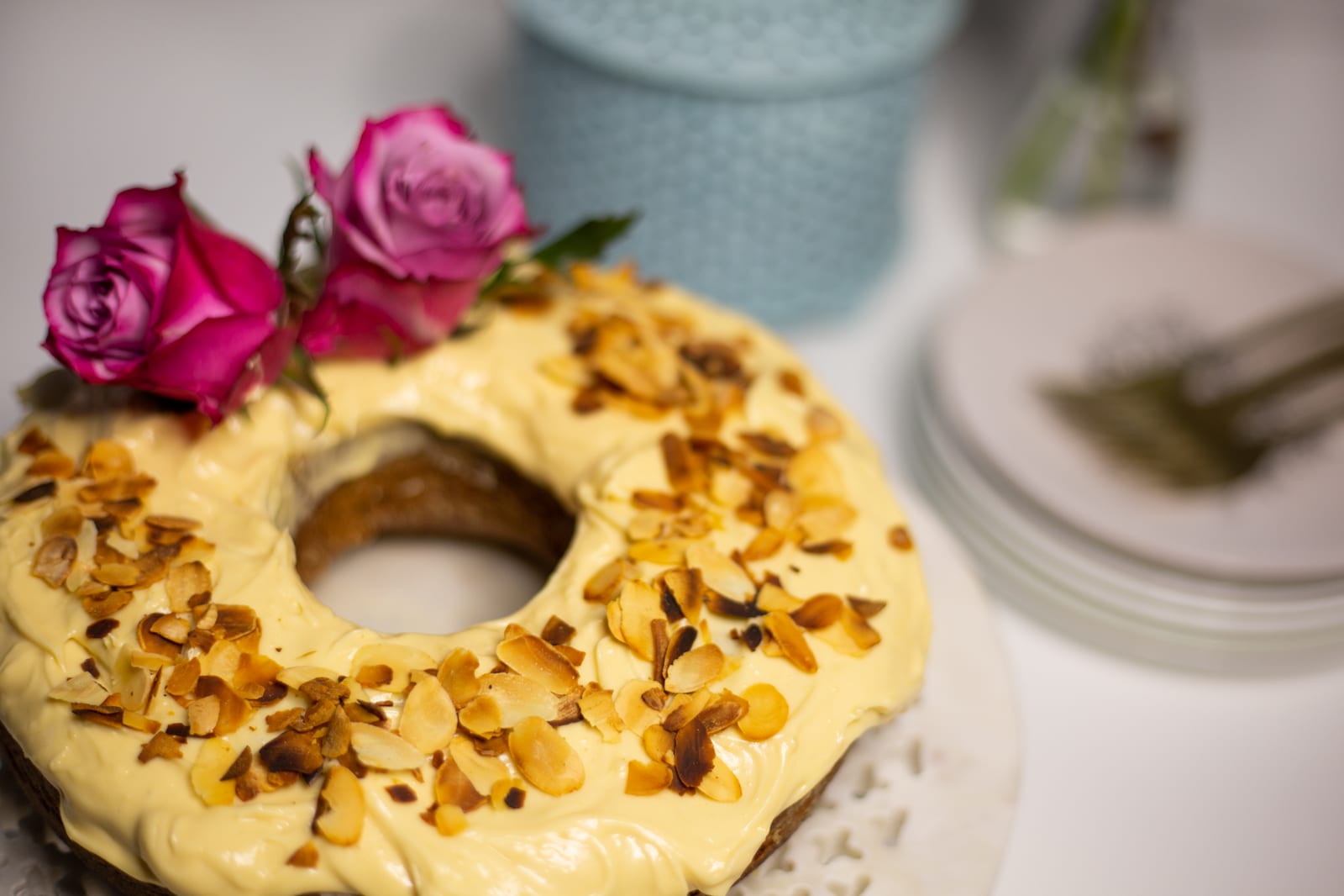 Close-up of the toasted almond flakes and pink roses on a citrus pound cake