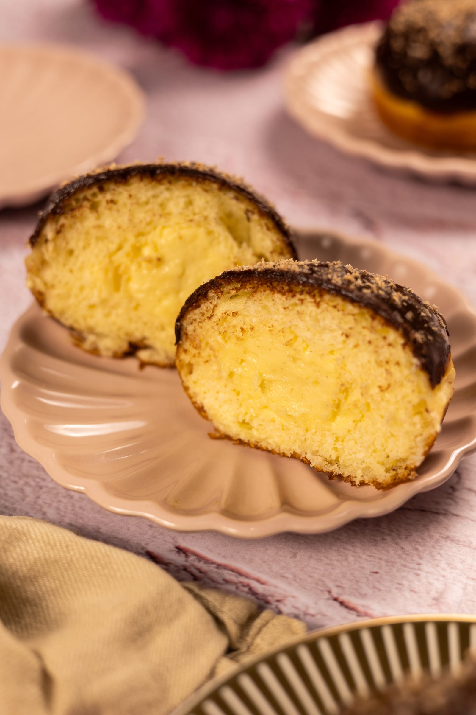 Two halves of a filled brioche donut on a pink plate