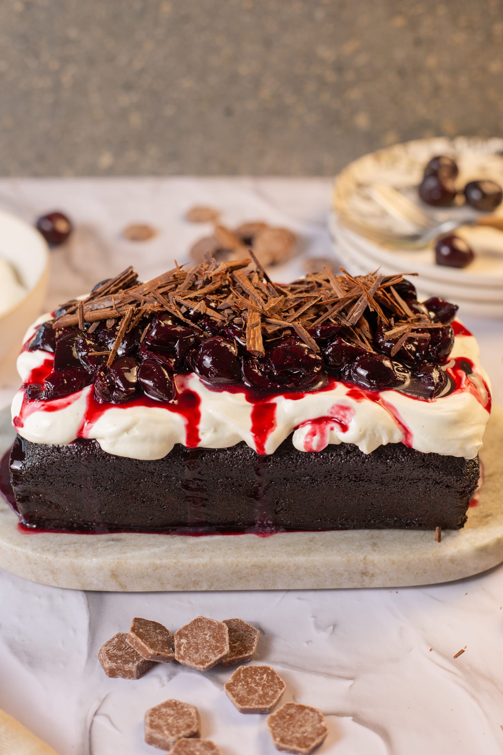 A black forest loaf with whipped cream, cherries and chocolate shavings