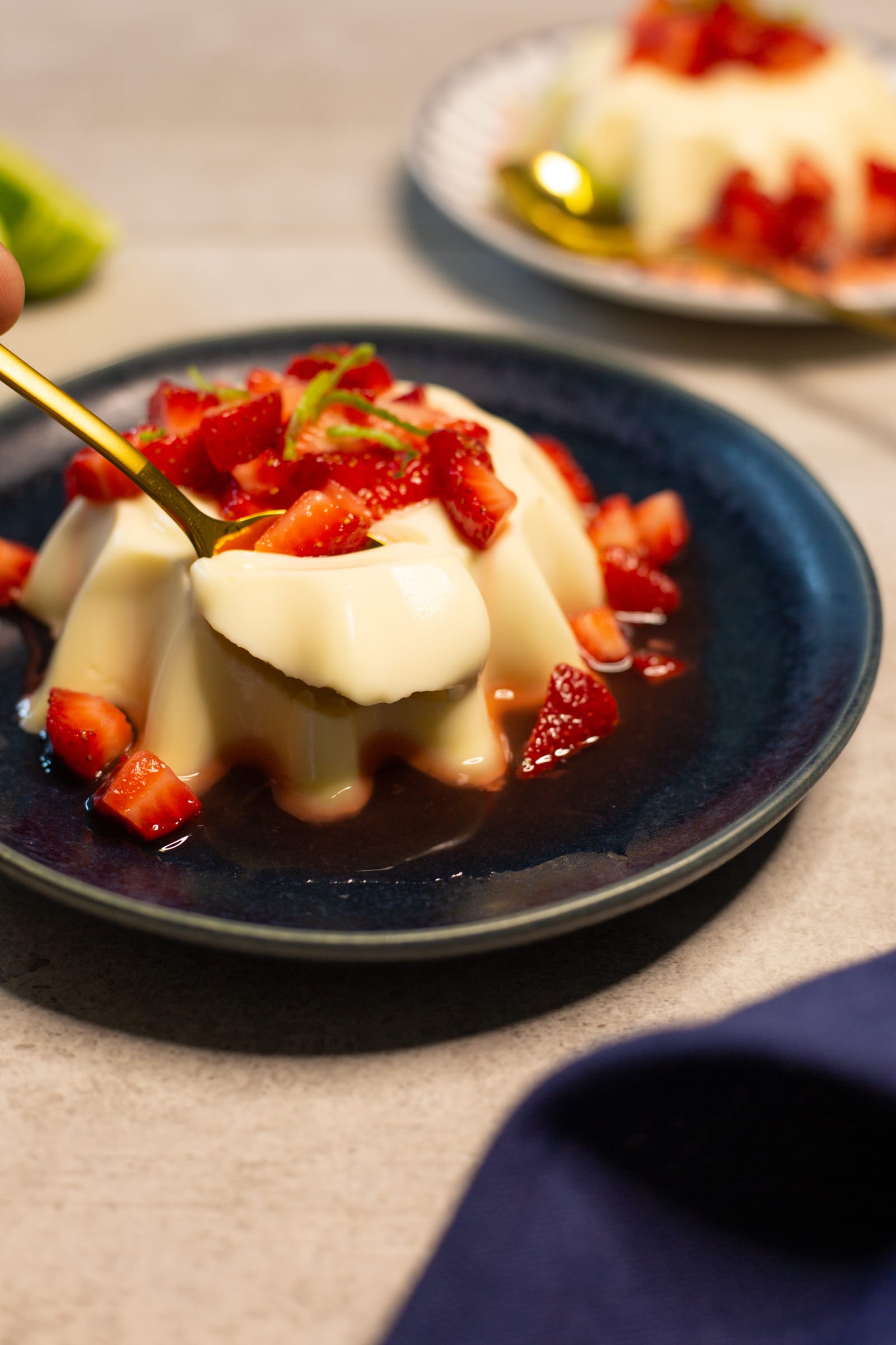 A gold spoon lifting a bite of lime panna cotta