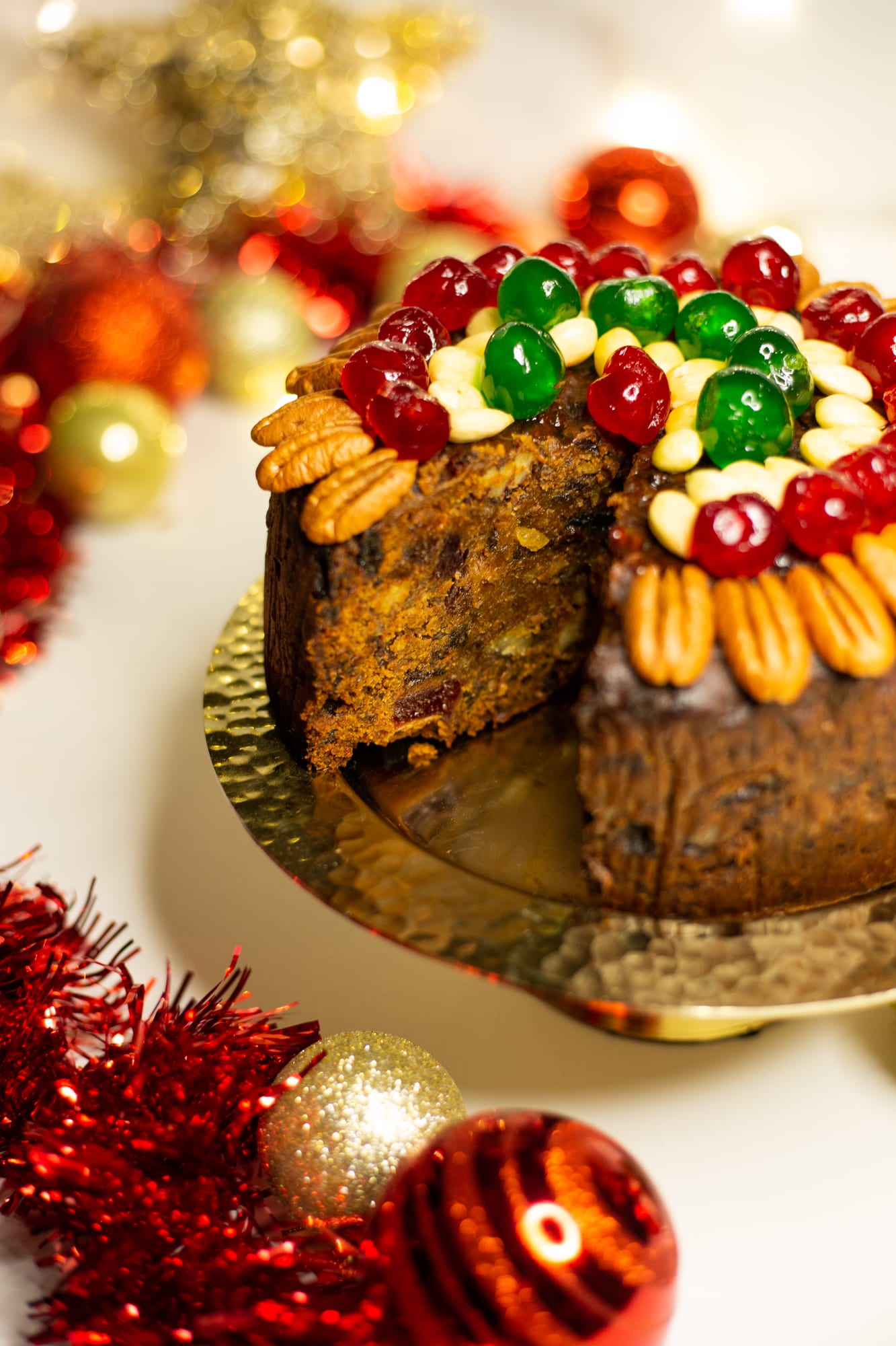 A cut boozy fruit cake, showing the fruit and nuts inside