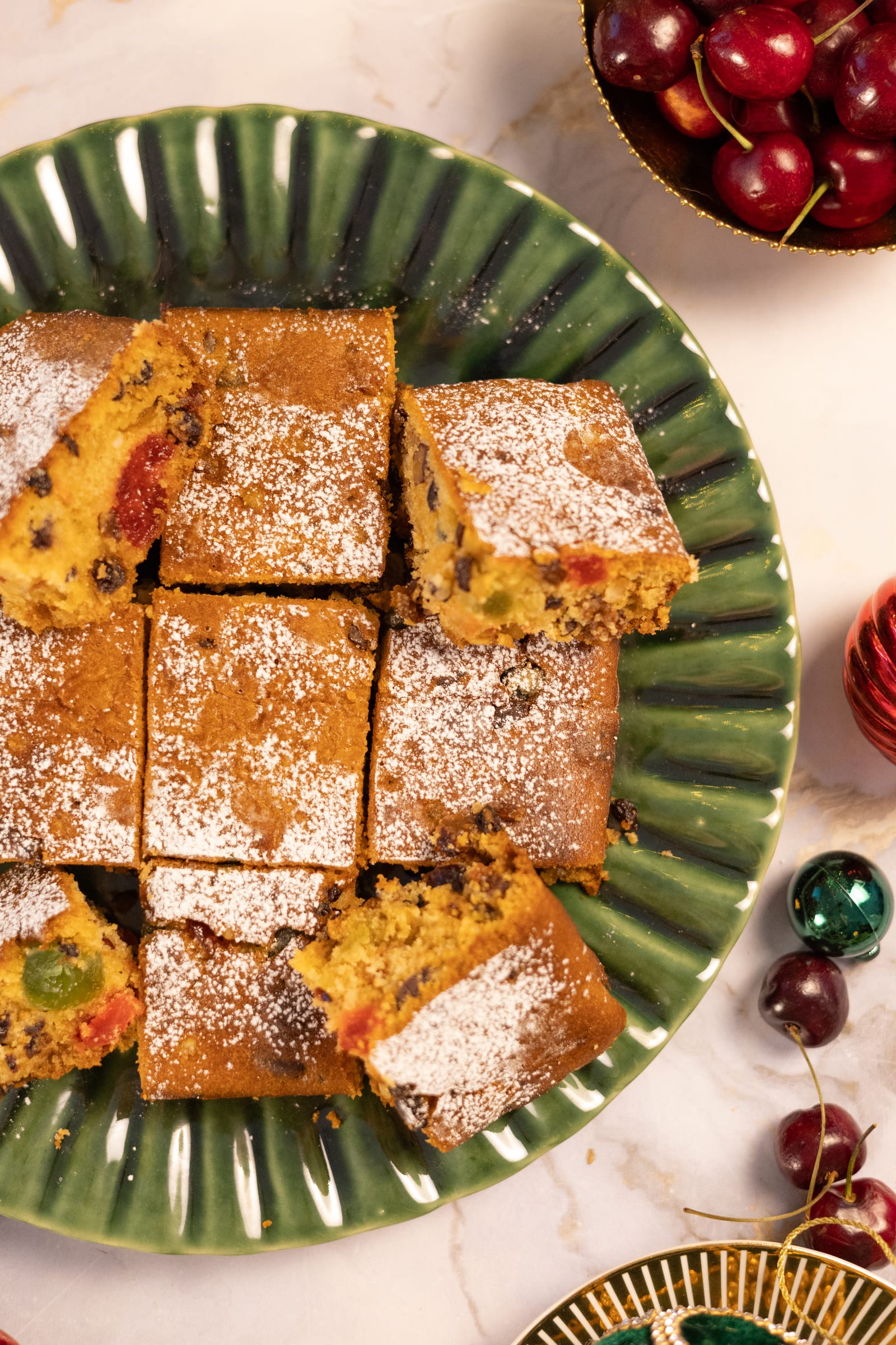 Squares of fruitcake on a green plate, from above