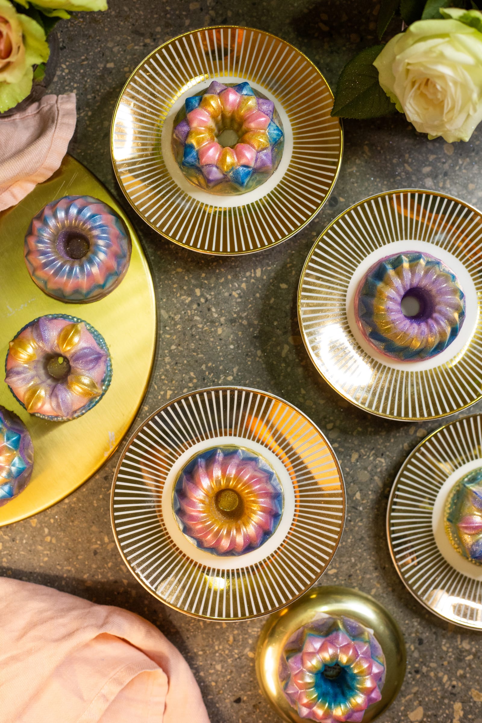 Dubai pistachio burfee bundts on gold-rimmed plates with roses, from above