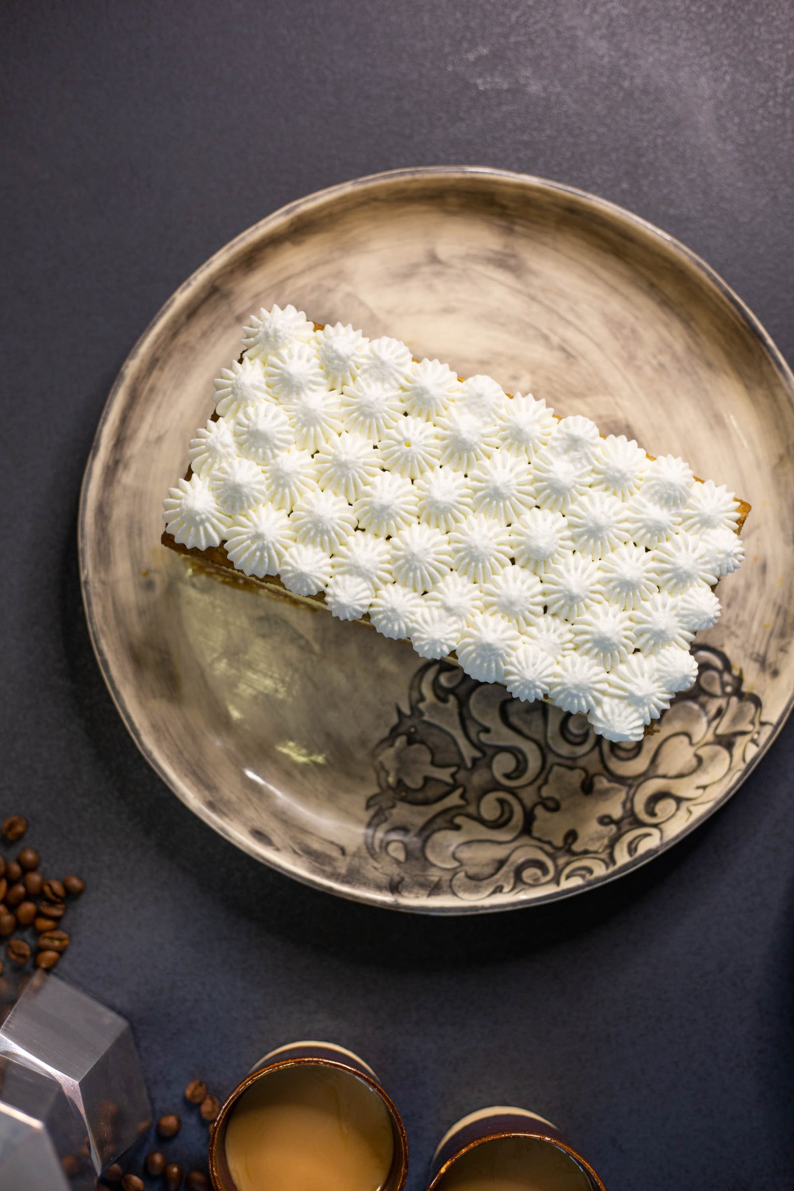 The tiramisu tres leches cake topped with rows of piped mascarpone cream, from above