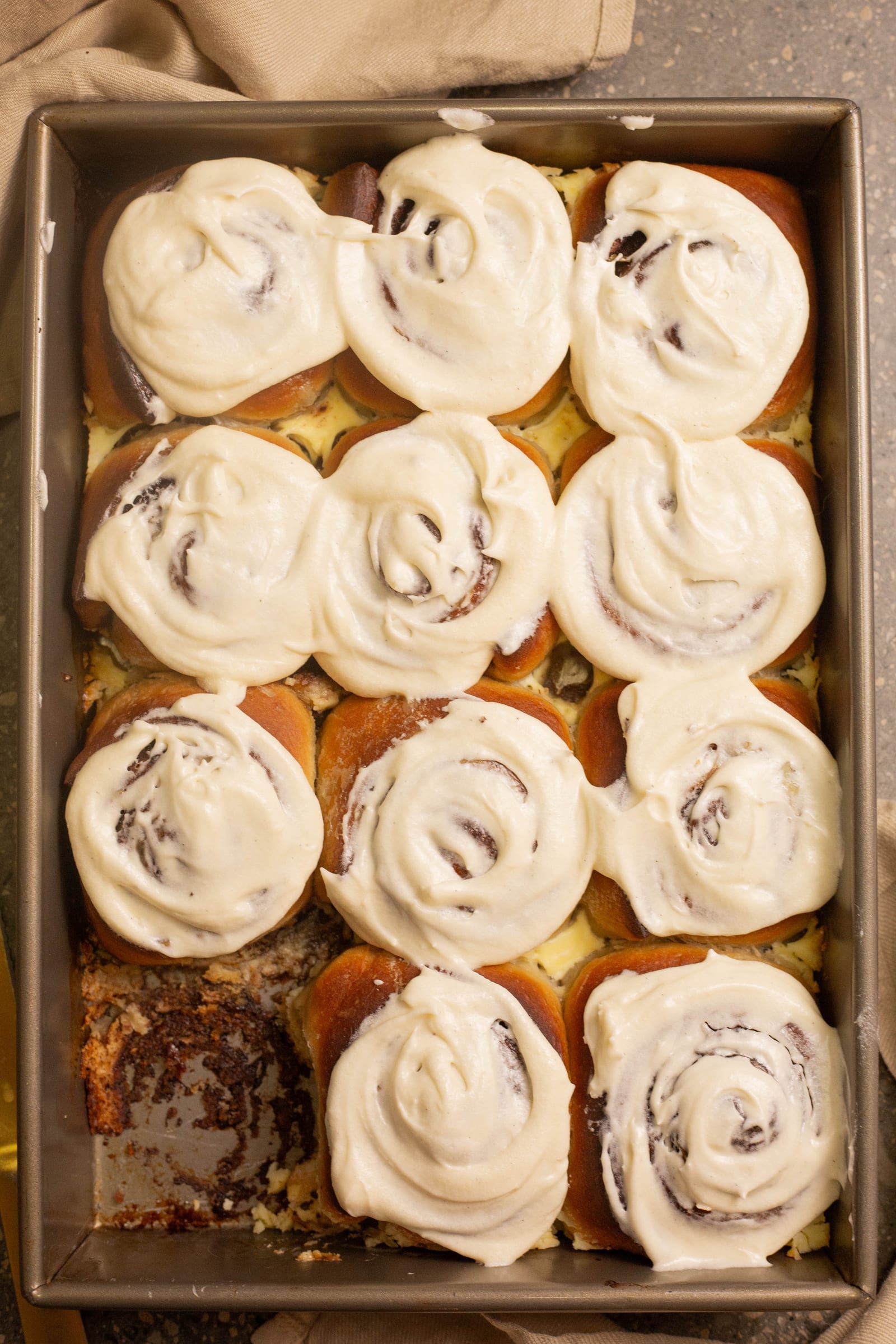 A full tin of iced cinnamon rolls, from above