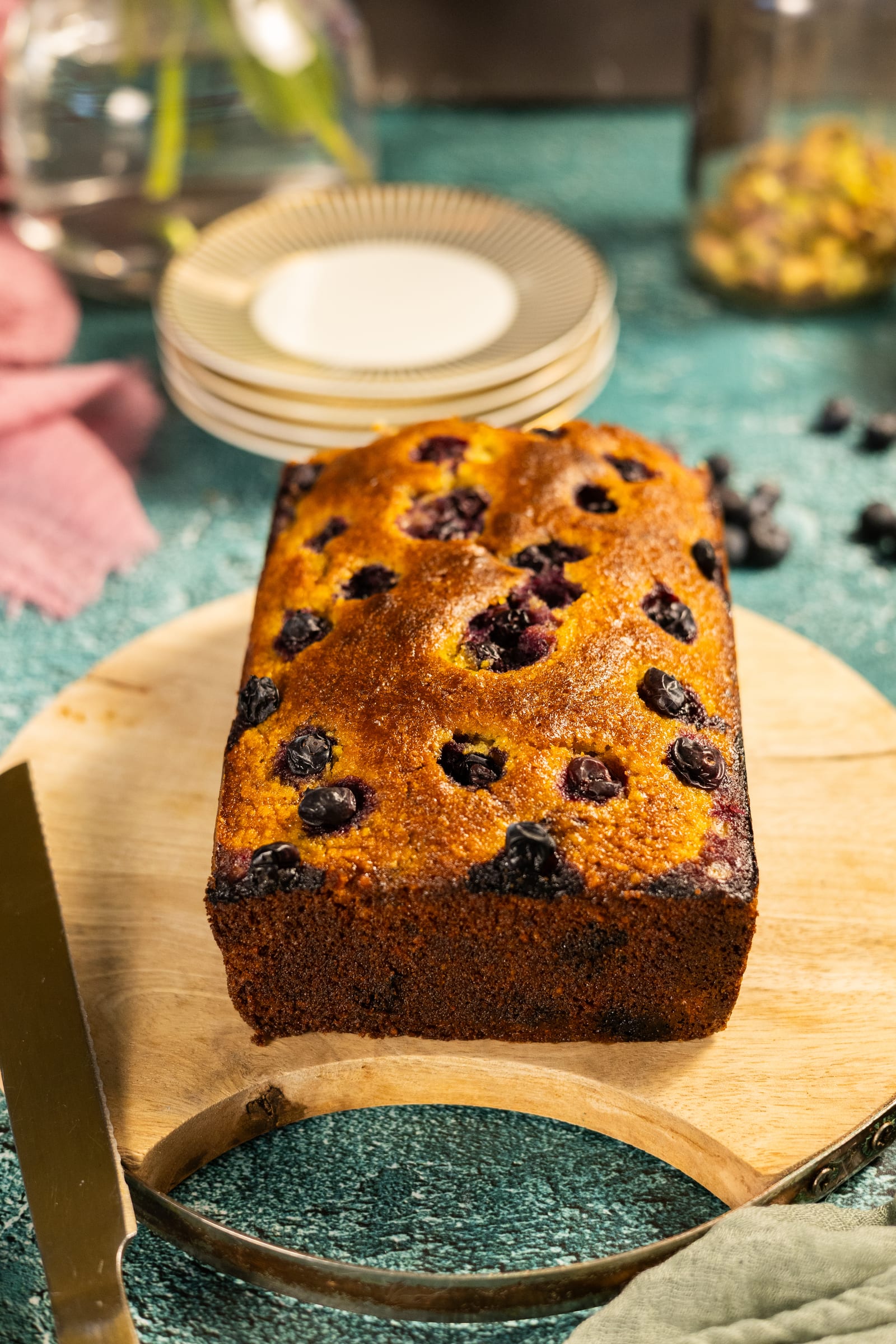 The baked loaf before glazing, dotted with blueberries