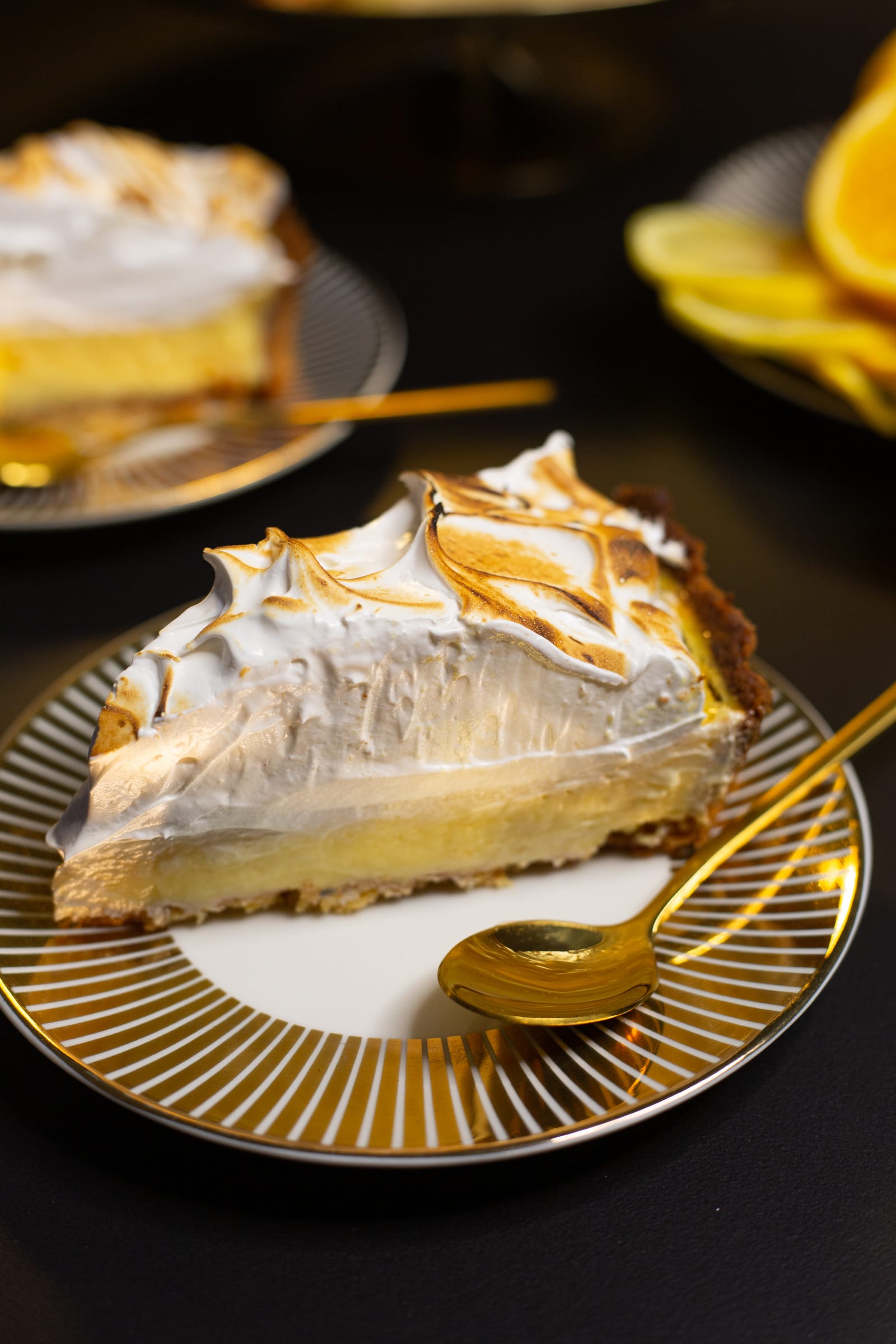 A slice of lemon meringue pie on a gold-rimmed plate