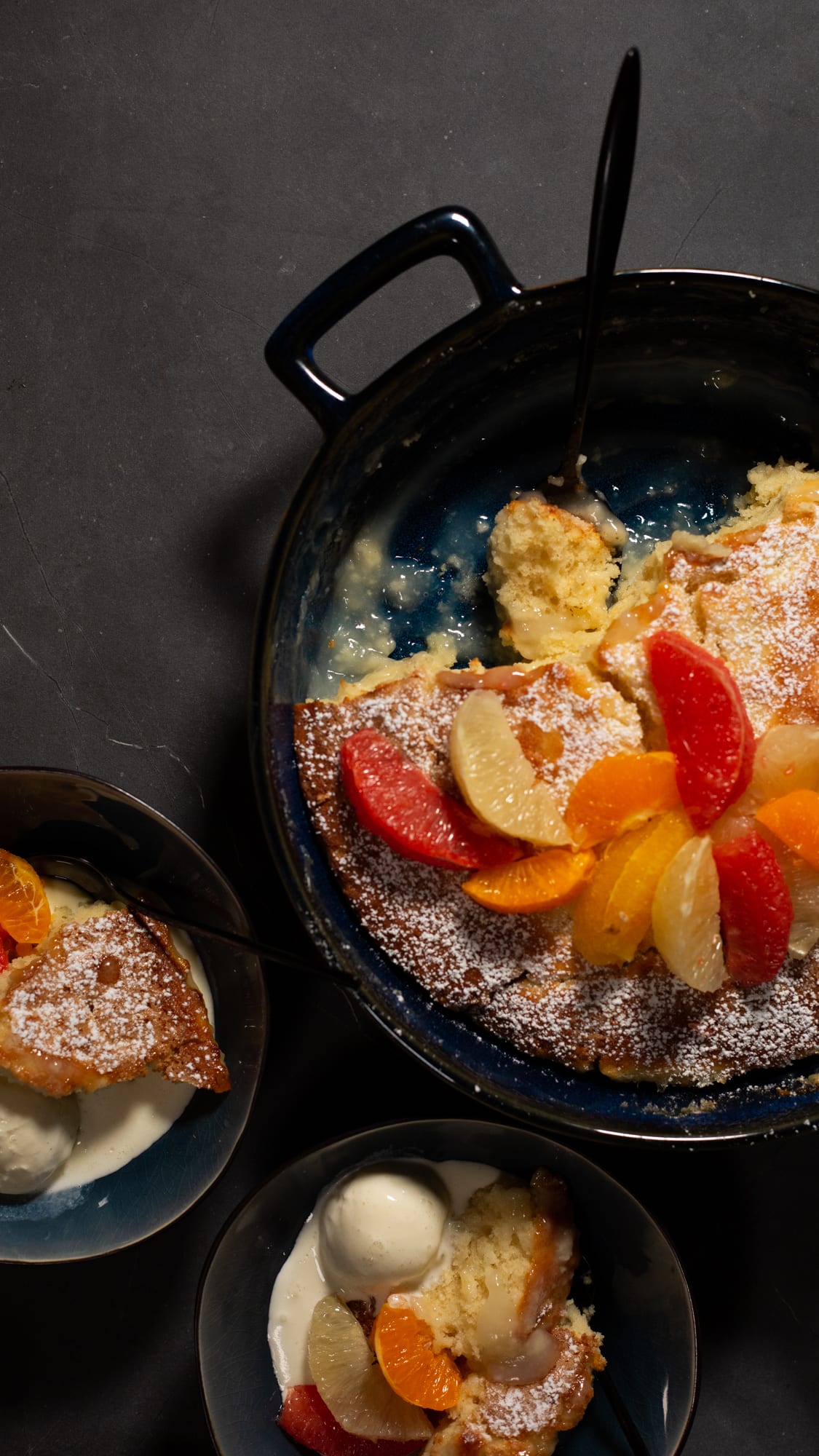 Bowls of citrus pudding beside the pan, from above