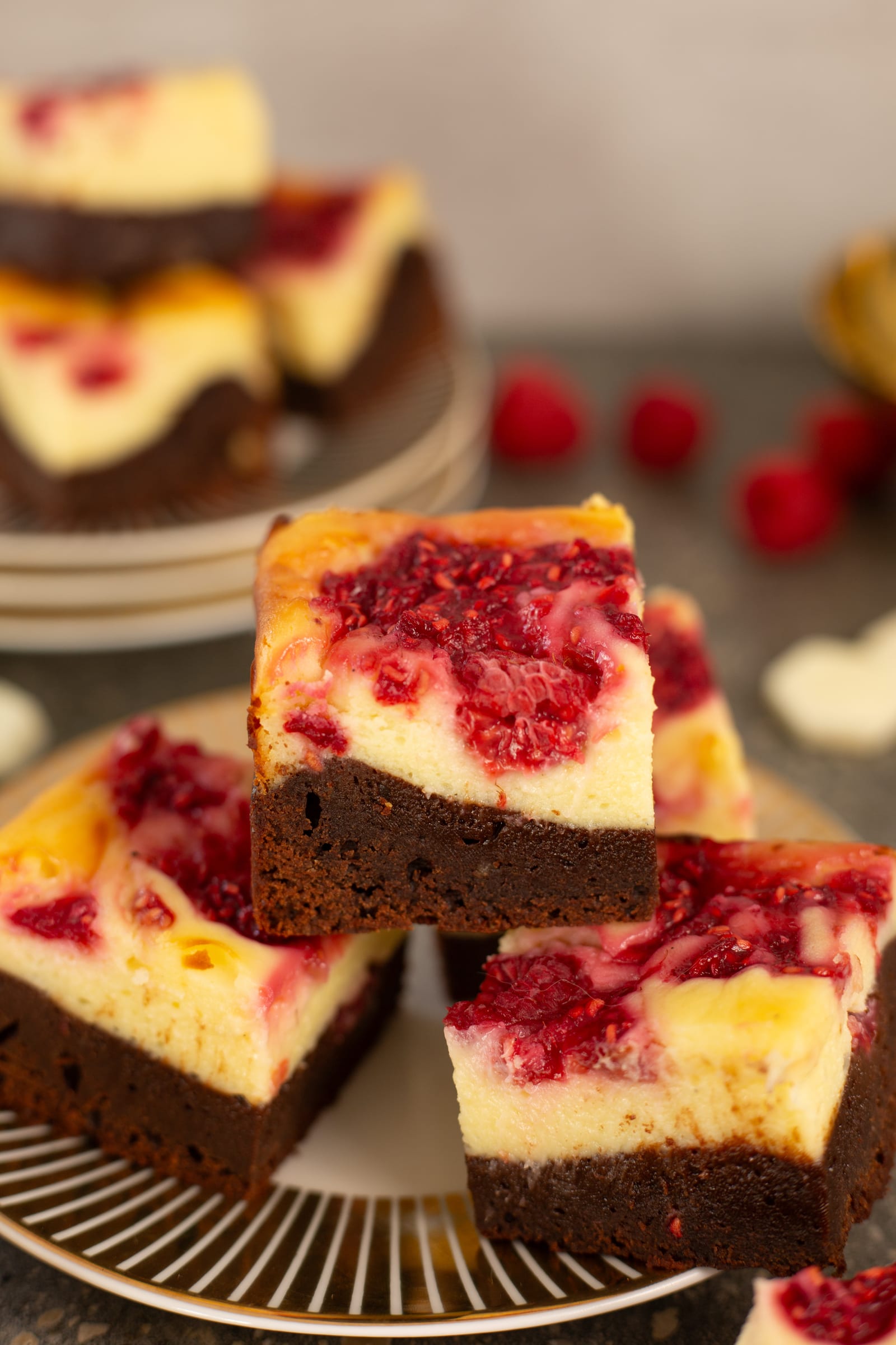 A stack of brownie bars showing the brownie and cheesecake layers