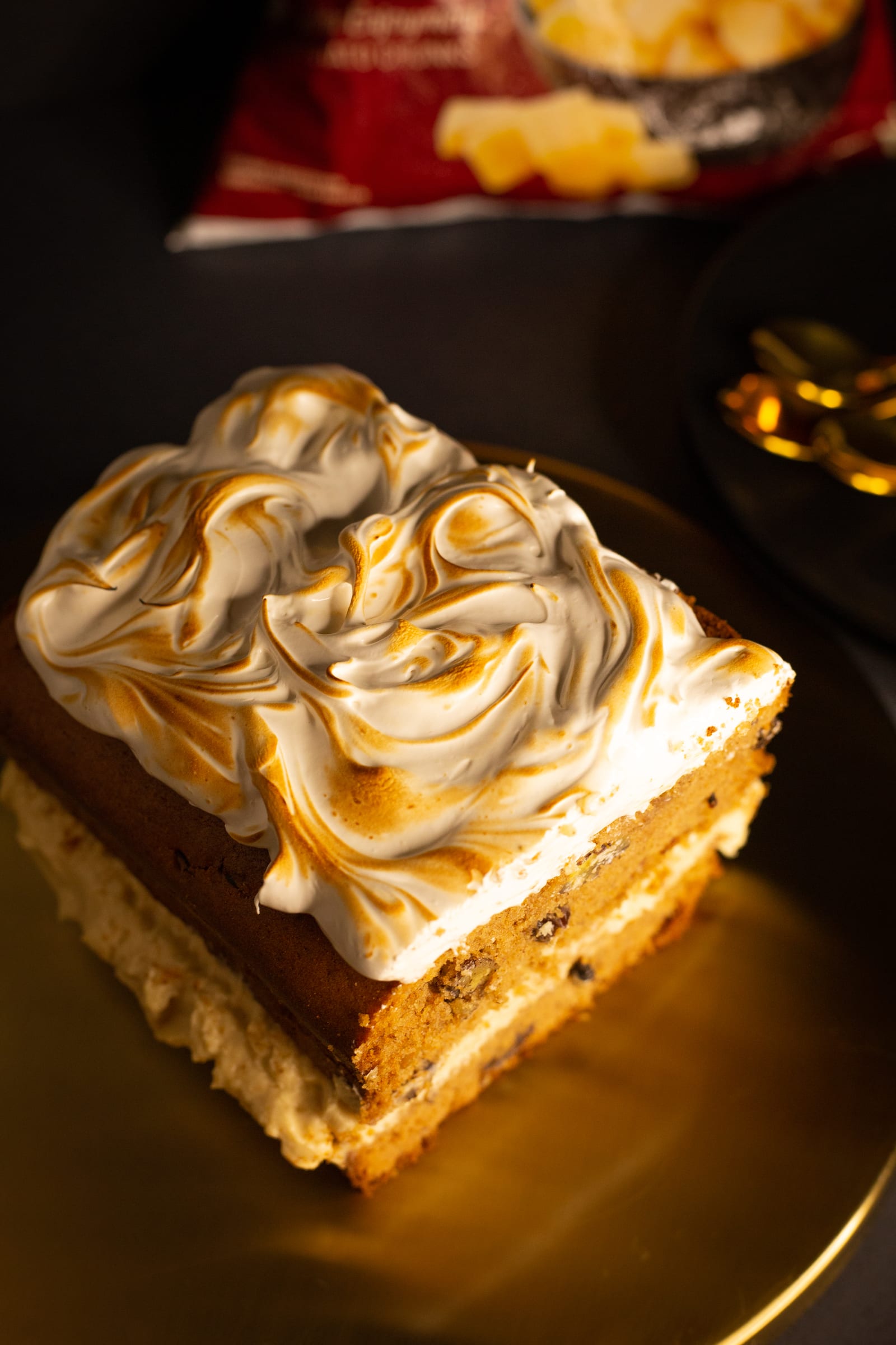 A piece of sweet potato loaf showing its toasted meringue top and the frosting in the crumb