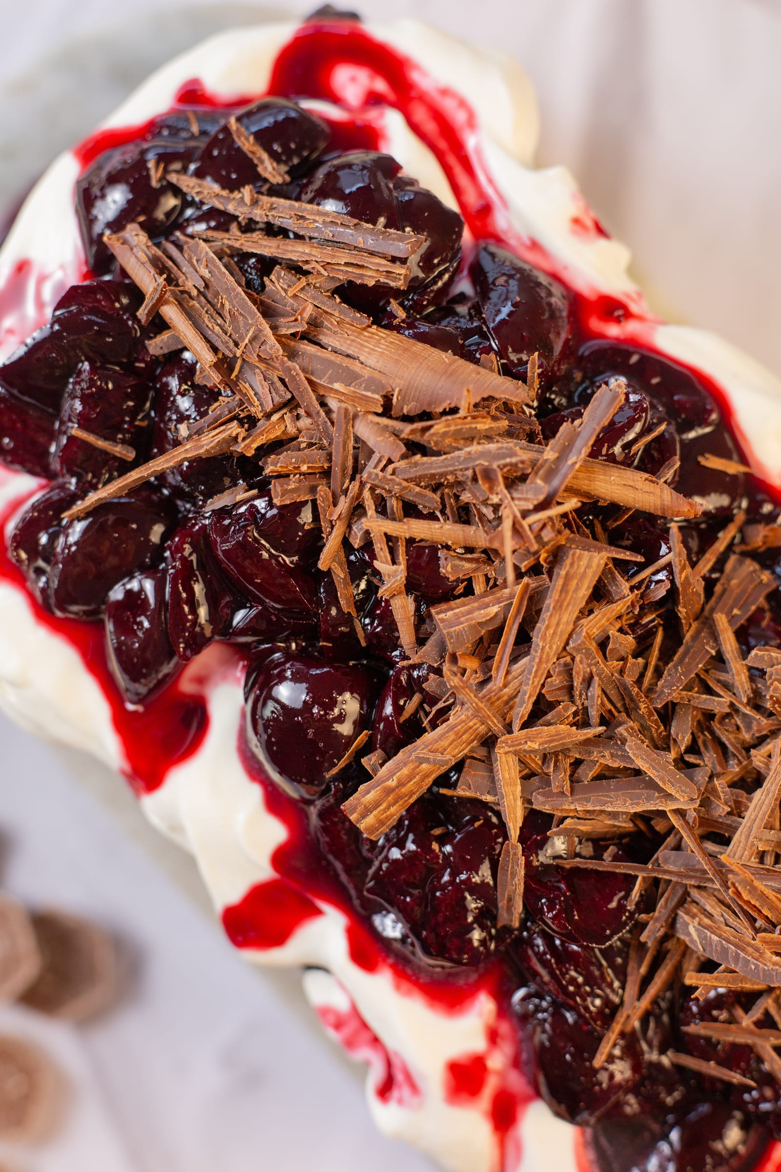 Close-up of cherry compote and chocolate shavings on whipped cream