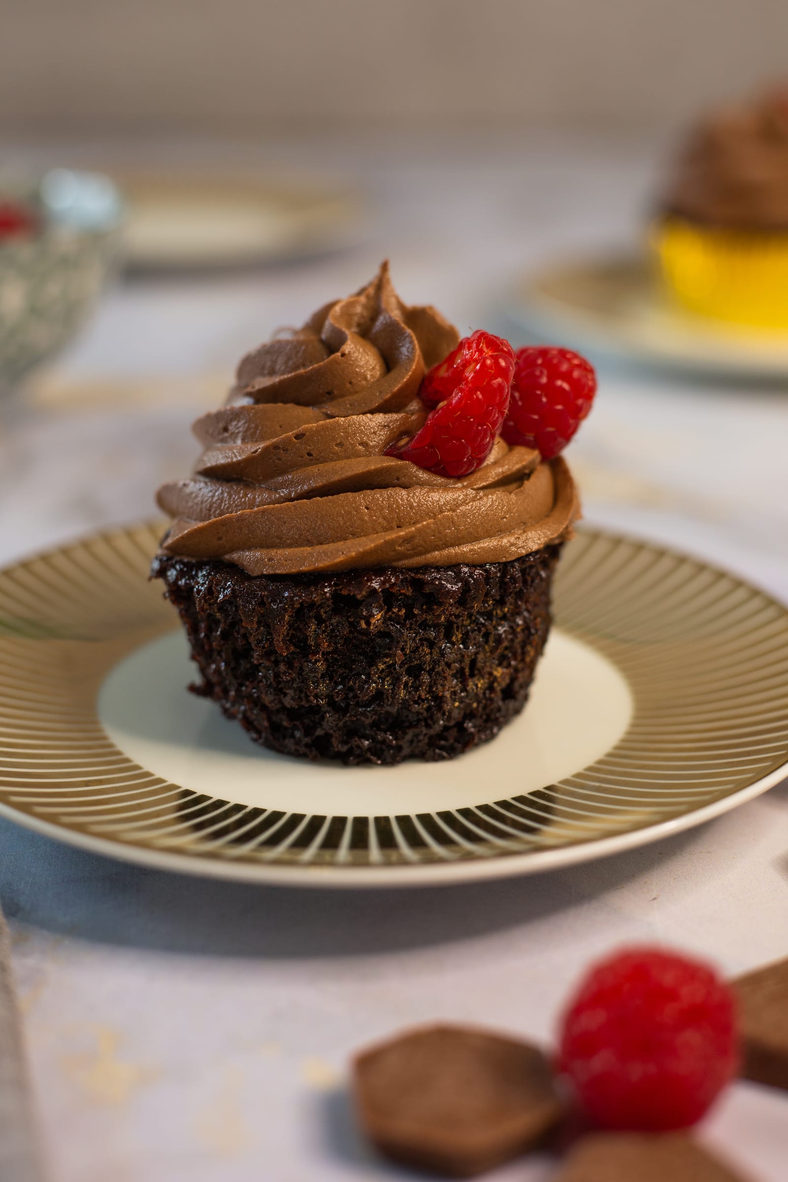 An ultimate triple chocolate cupcake out of its case, showing the dark crumb