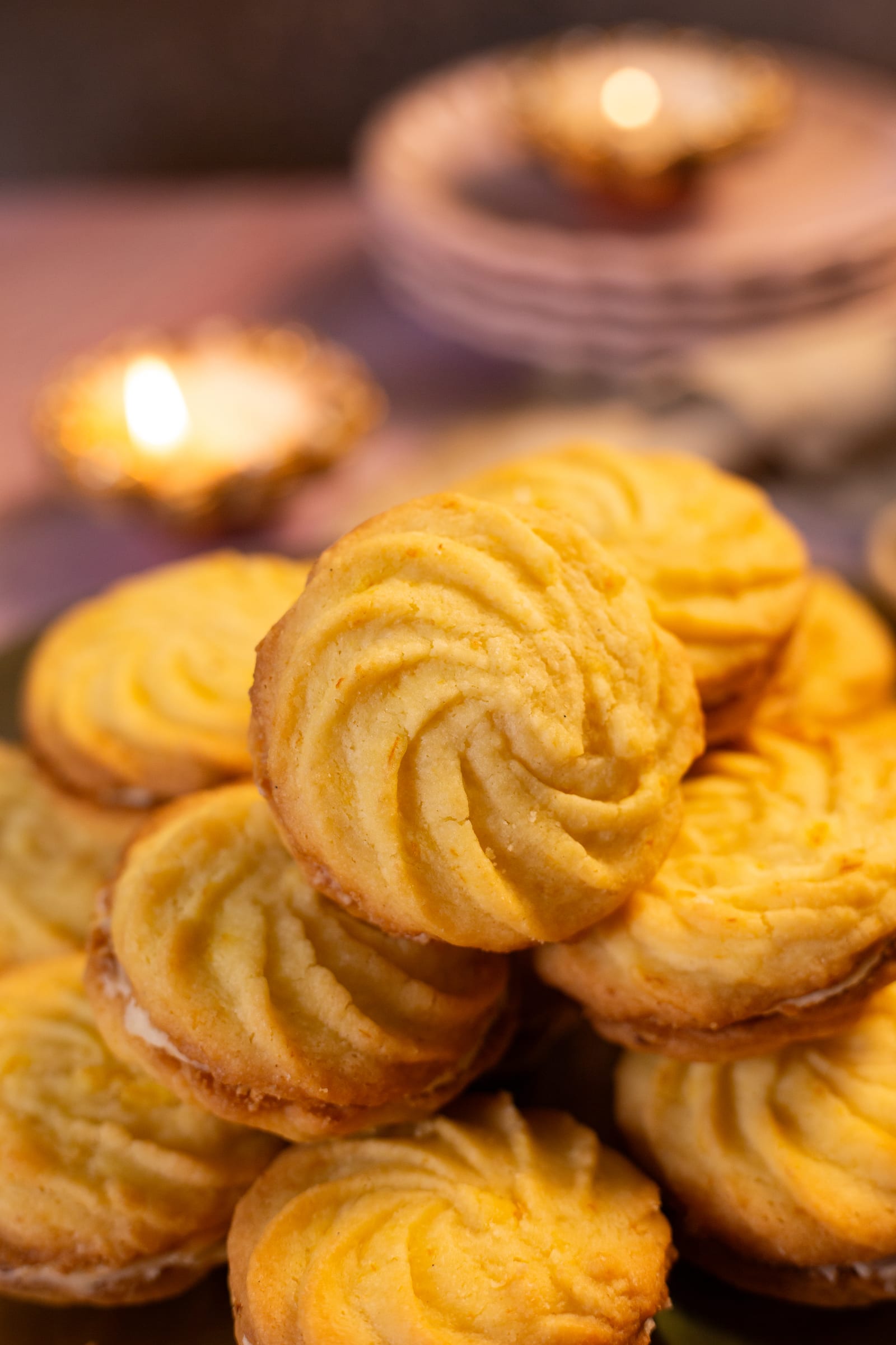 A stack of melting moments, with a candle glowing behind