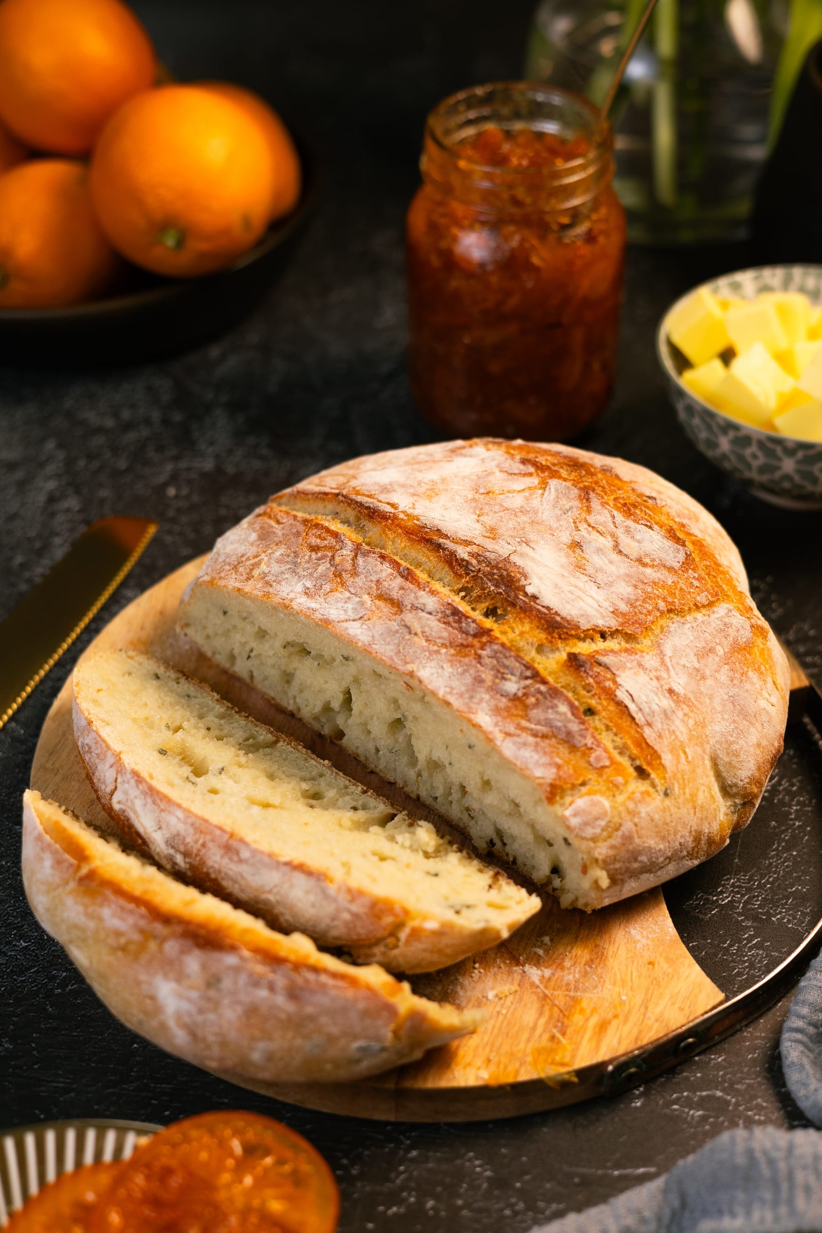The sliced loaf on a board, with a jar of marmalade and butter