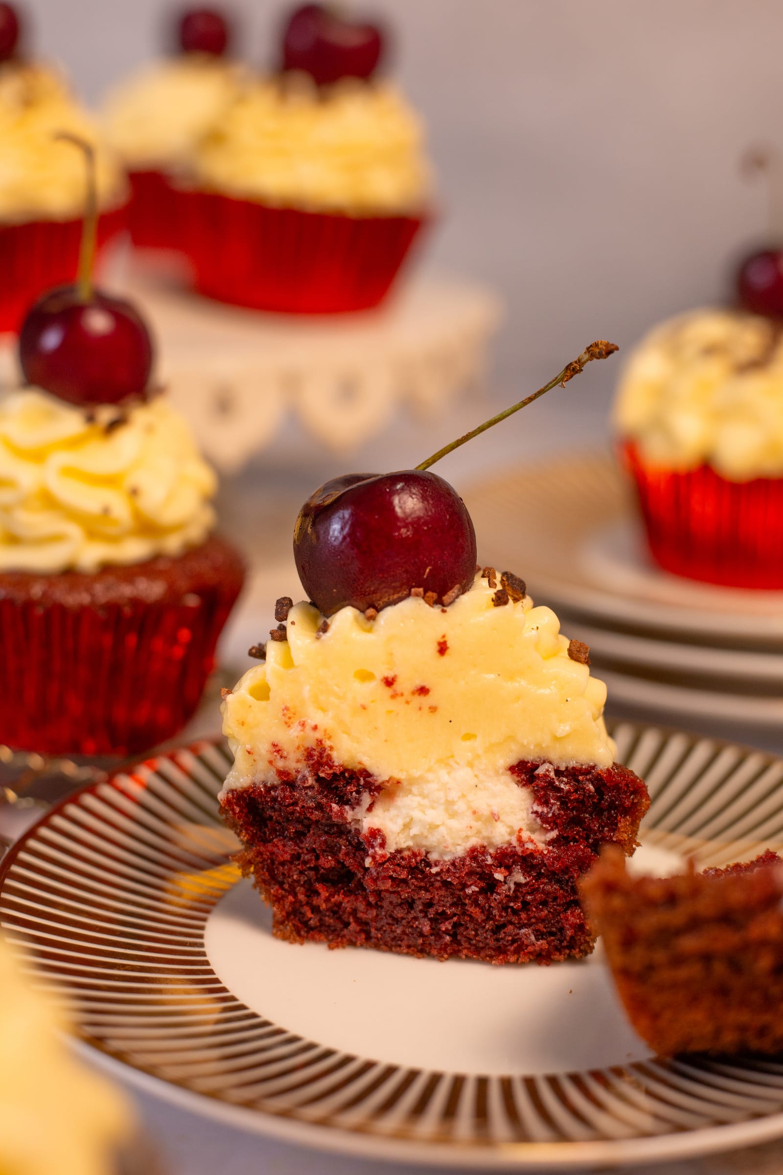 A red velvet cupcake cut open to show the white chocolate cream filling