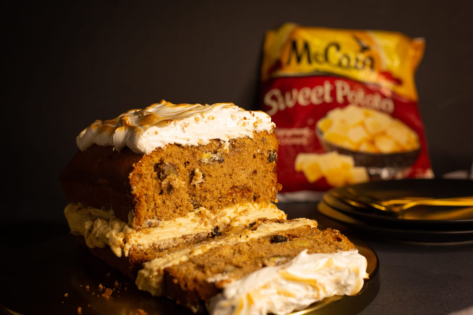 A sweet potato loaf with brown butter maple frosting, cut with slices fanned out in front, from the side