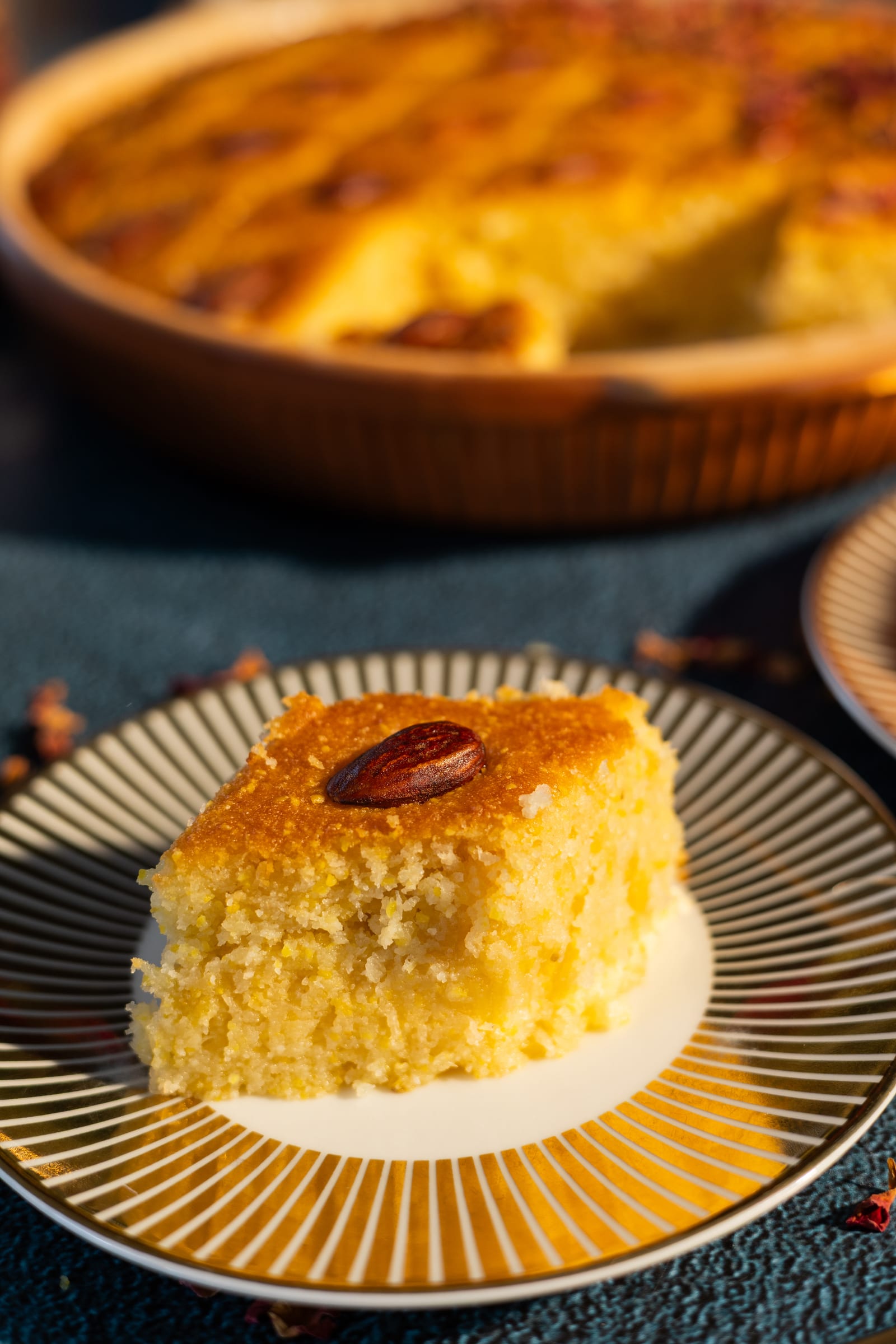 A square of basbousa on a gold-rimmed plate