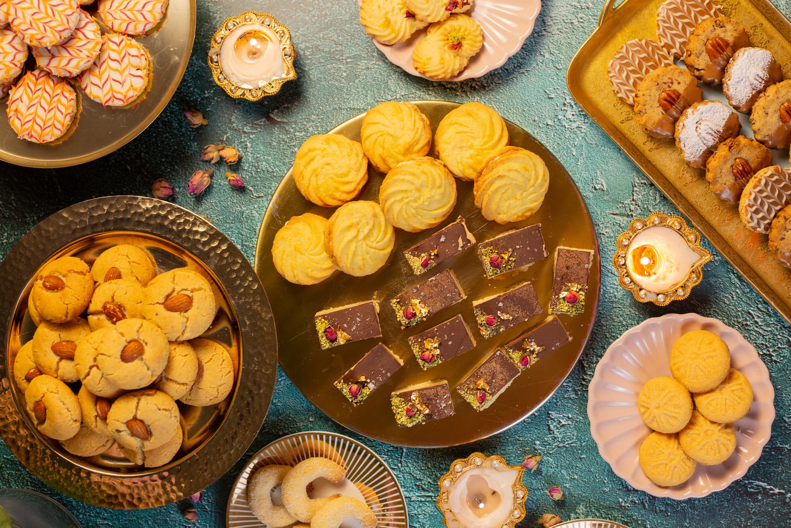 A spread of Diwali biscuits on gold trays and plates, from above