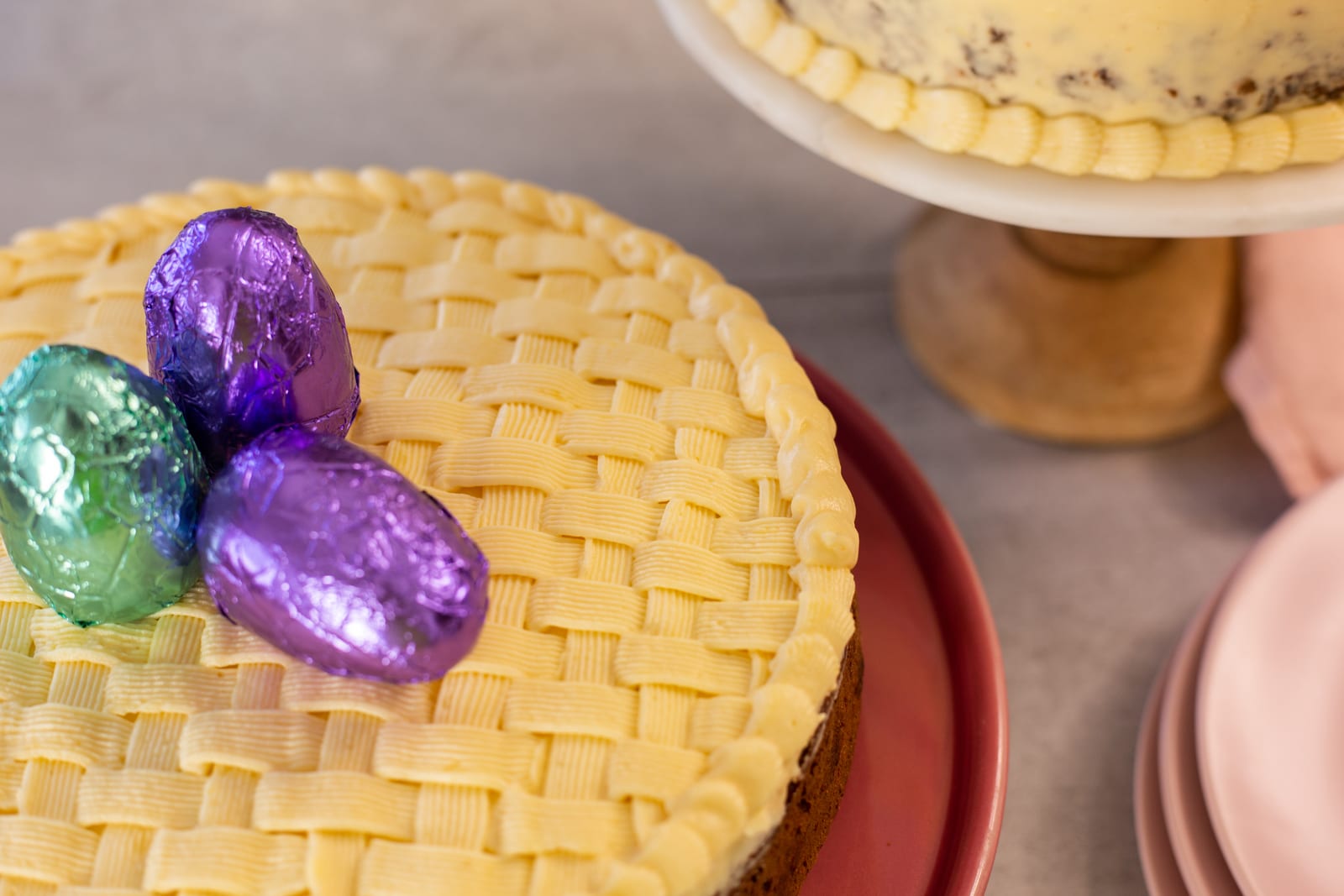 Purple and teal foil Easter eggs on the basketweave frosting of a gluten-free carrot cake