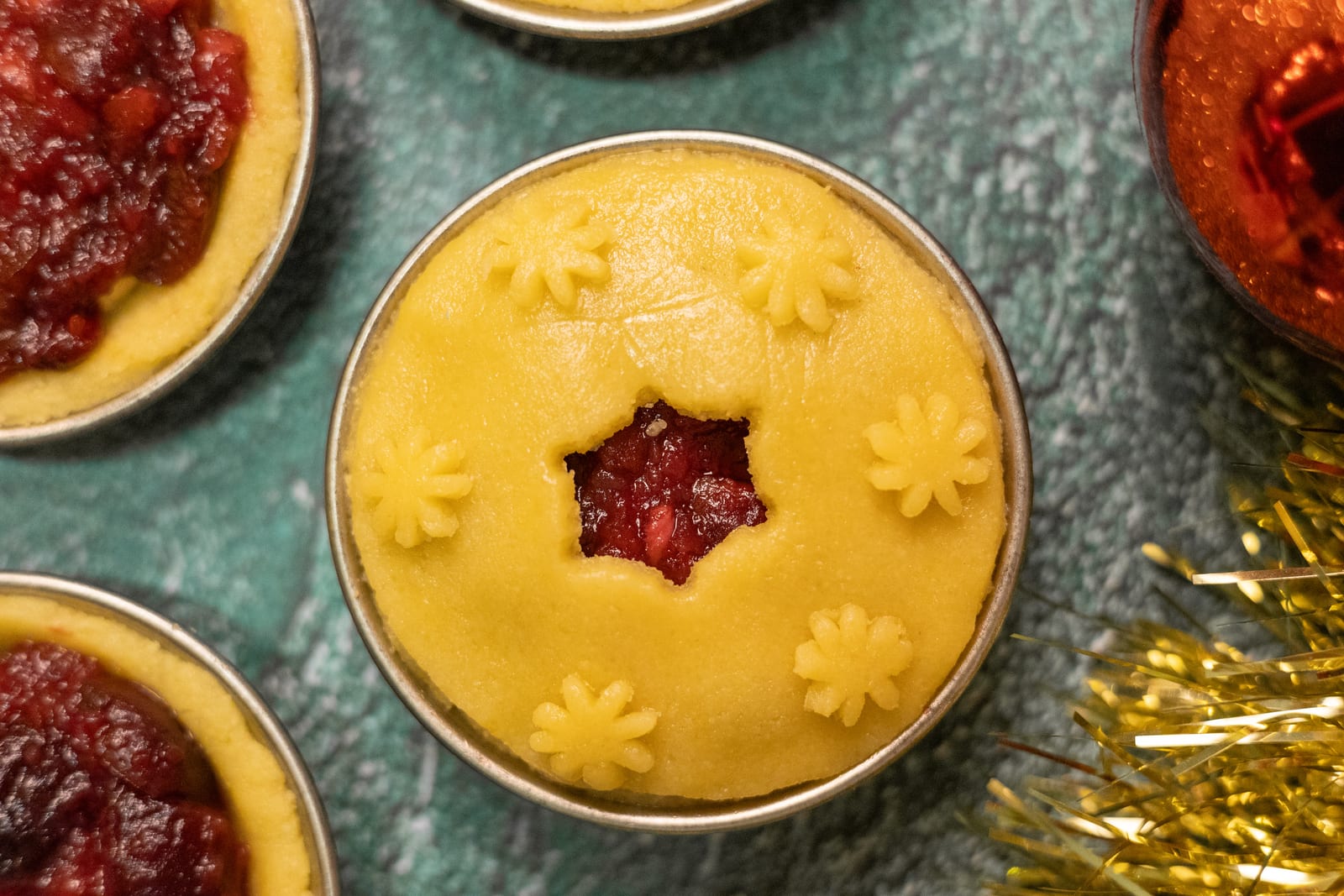 Pies topped with pastry lids and star cut-outs, before baking