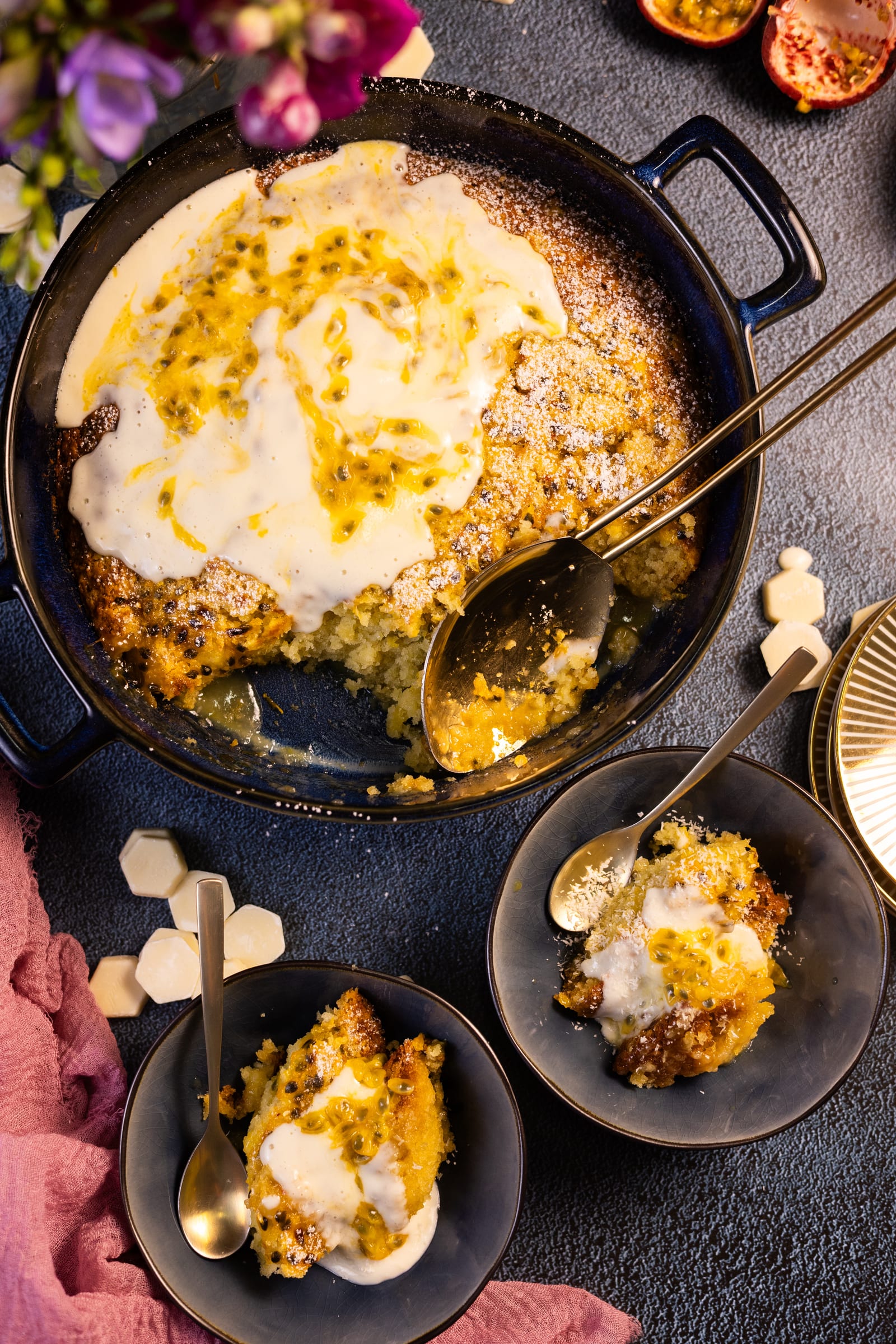 The self-saucing pudding topped with coconut cream and passionfruit, with bowls served alongside