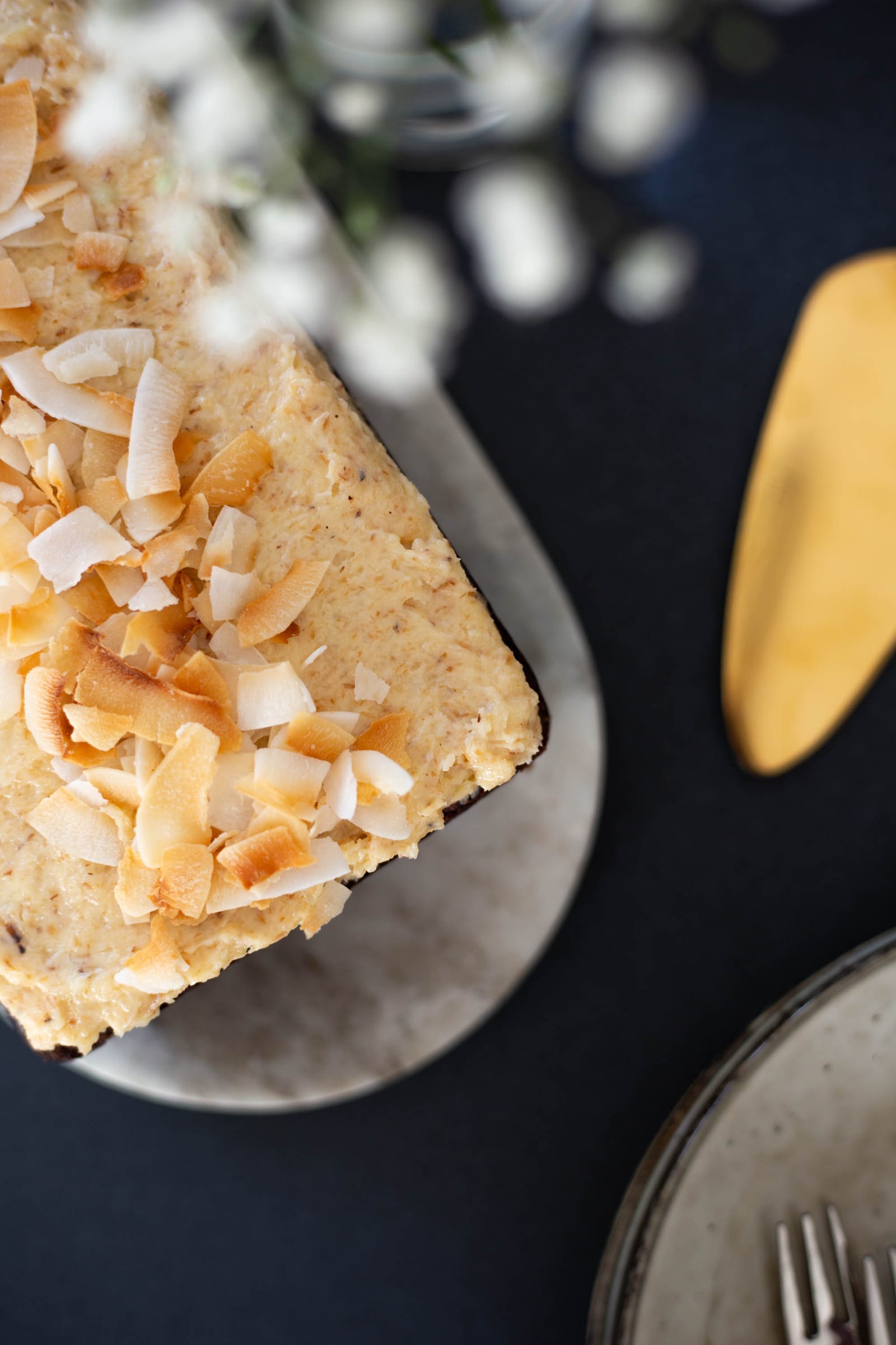 Close-up of the toasted coconut flakes on top of a gluten-free coconut loaf, from above