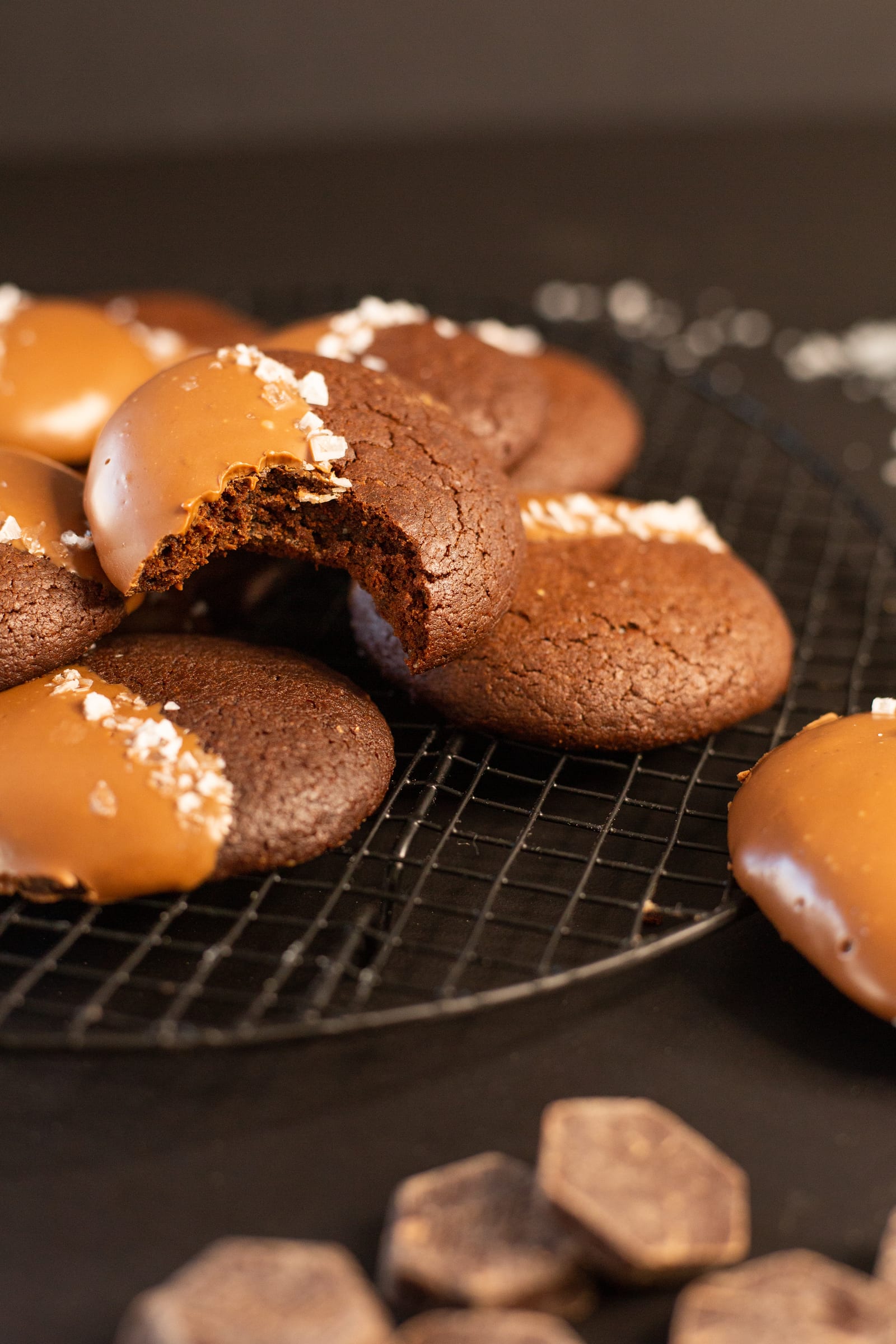 A bitten rye brownie cookie on the pile, with chunks of chocolate in front