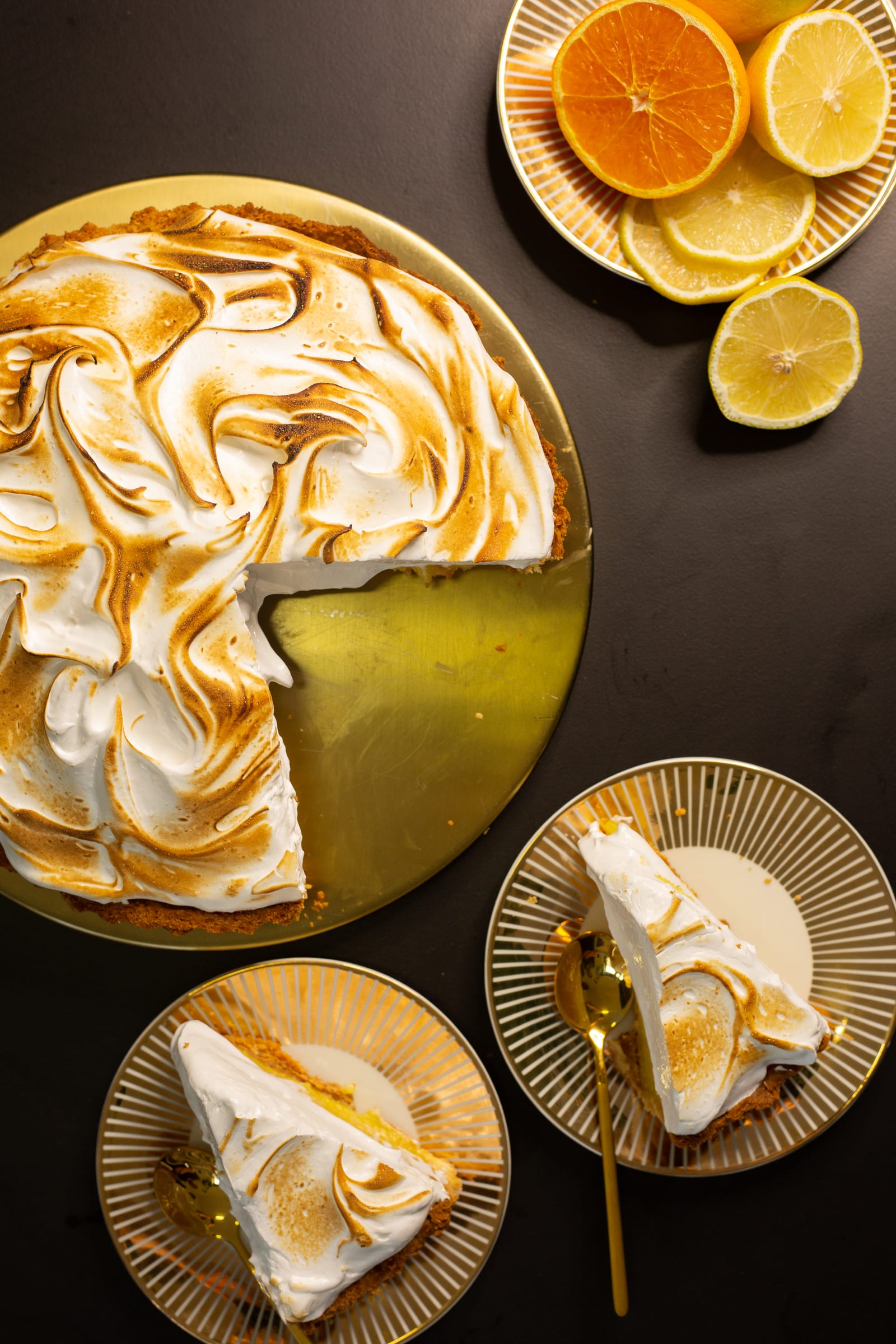The cut lemon meringue pie from above, with two slices on plates