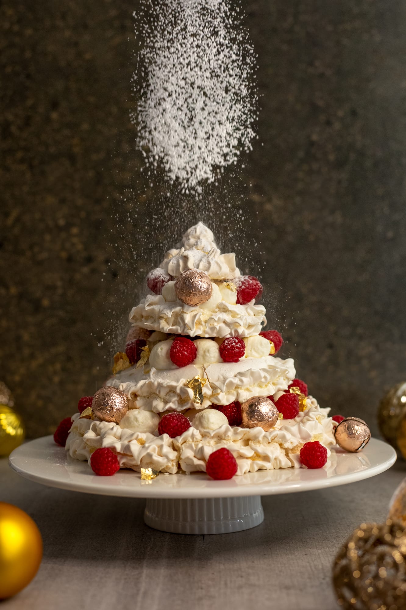 Icing sugar being dusted over a Christmas tree pavlova