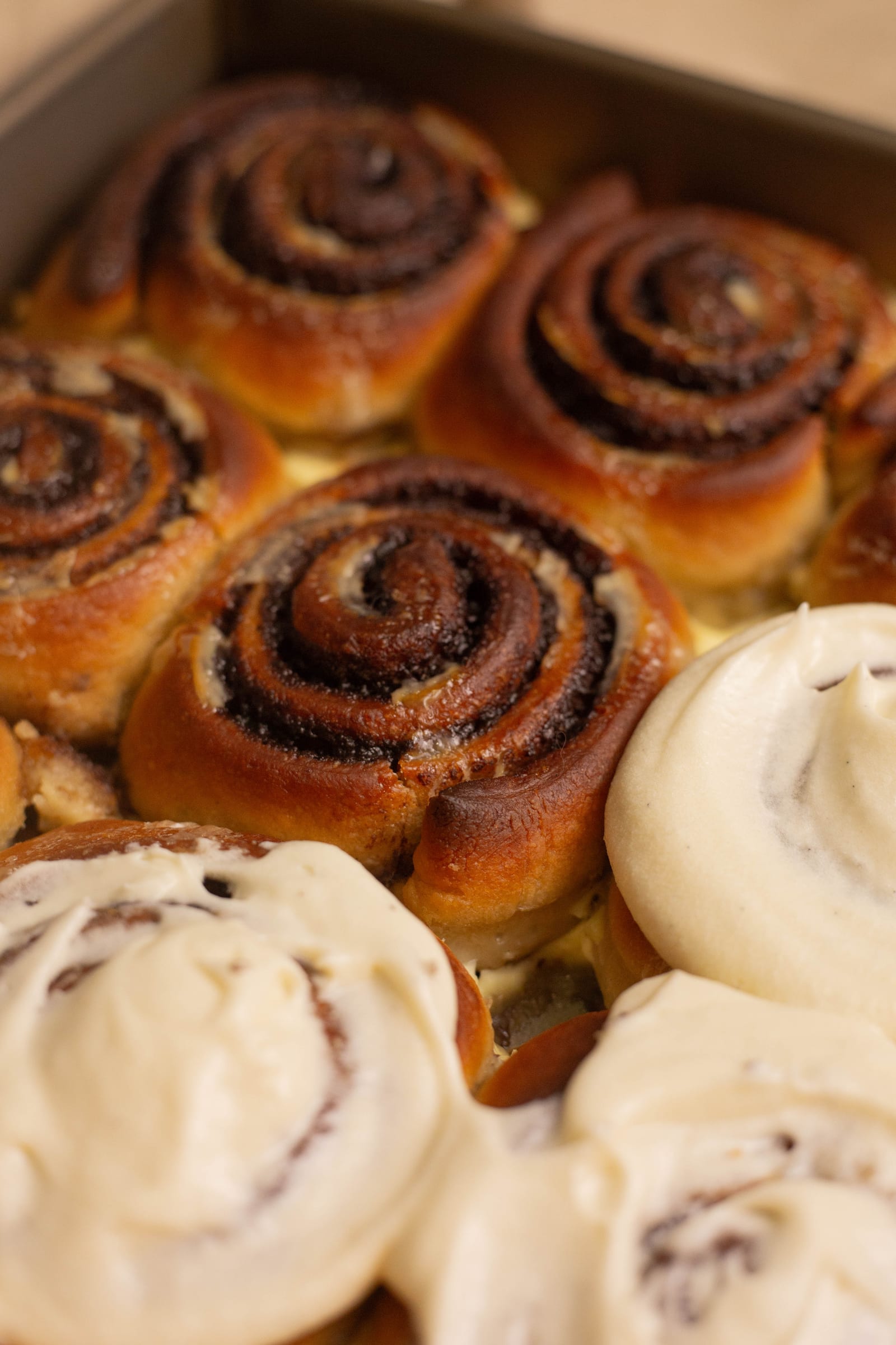 Close-up of iced cinnamon rolls showing their spiced swirls