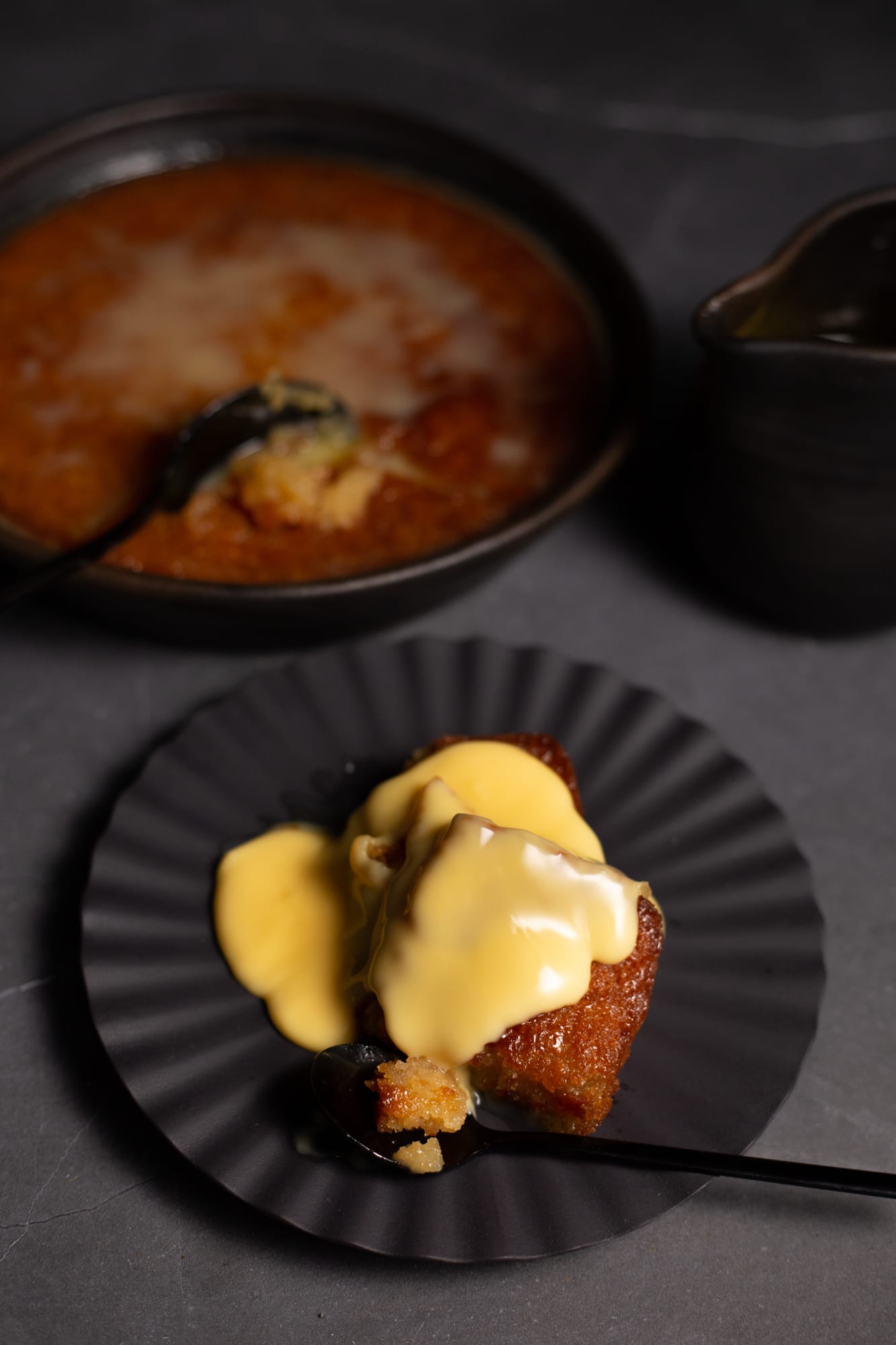 A serving of malva pudding topped with crème anglaise