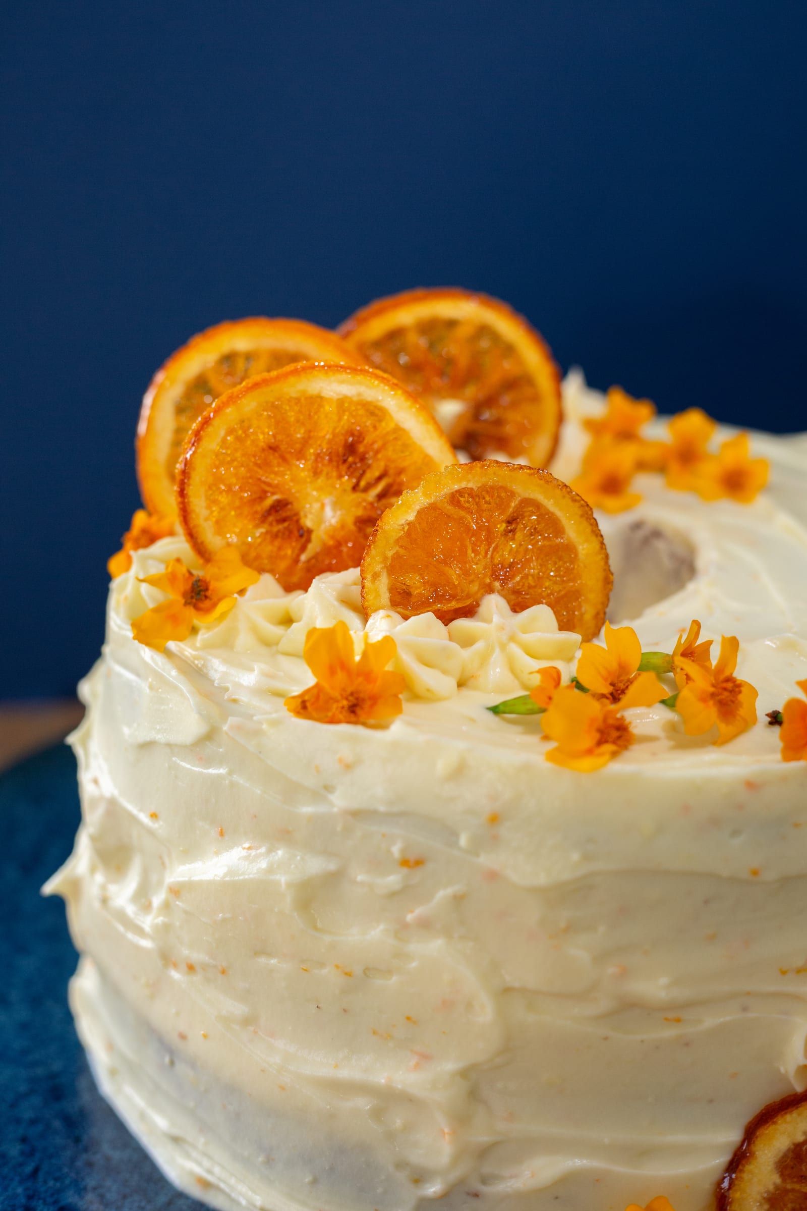 Close-up of the candied orange slices and small flowers on top of the orange cream chiffon cake