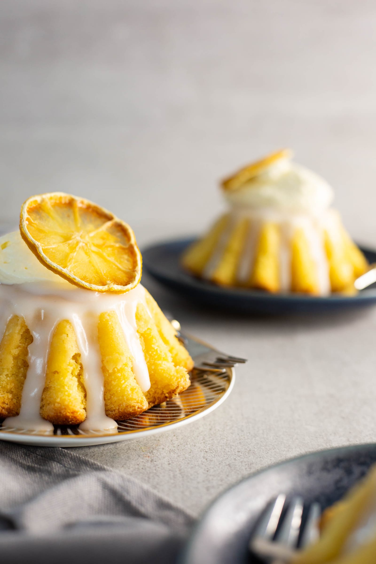 A glazed semolina mini cake topped with a dried lemon slice