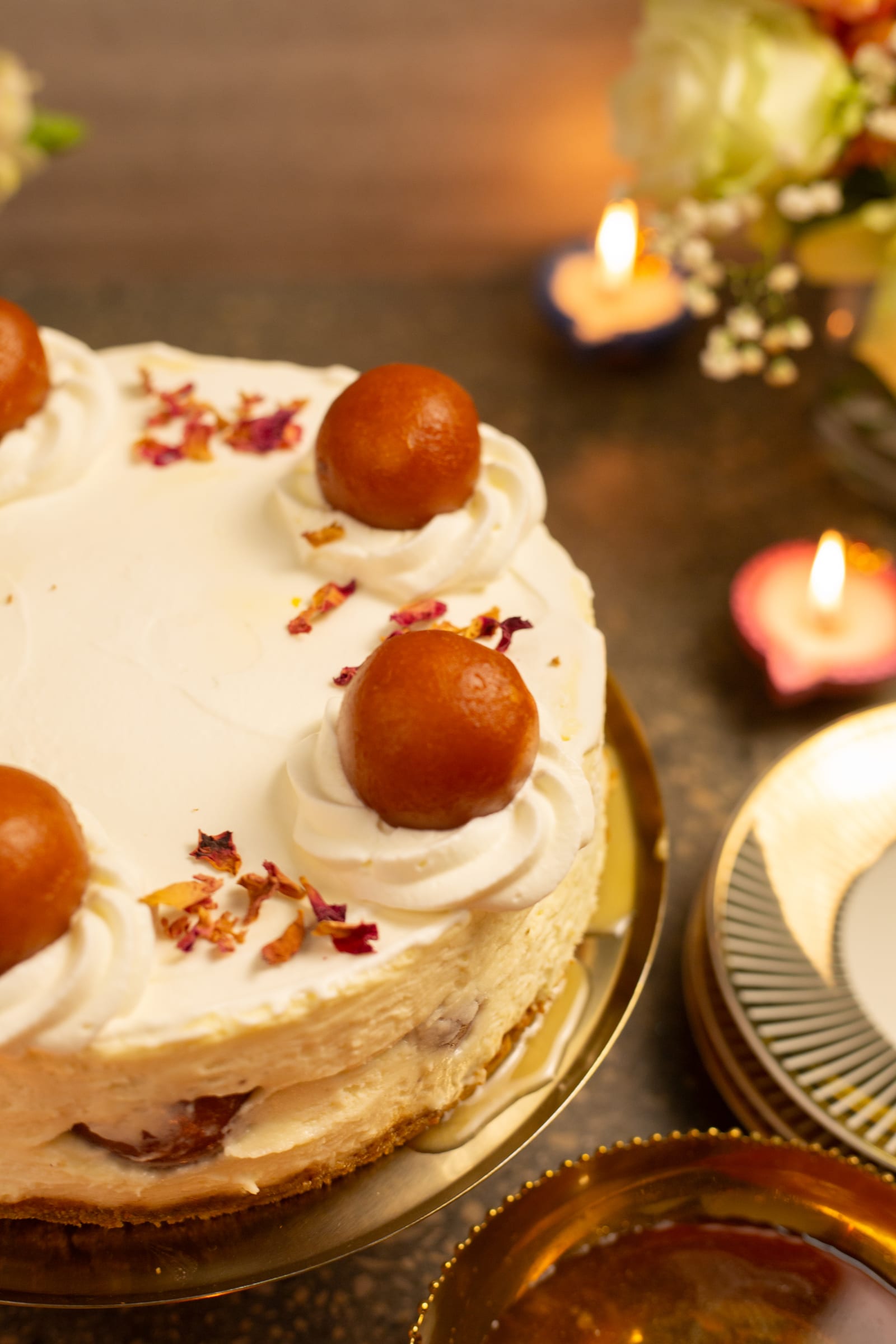 Gulab jamun on cream rosettes at the edge of the cheesecake