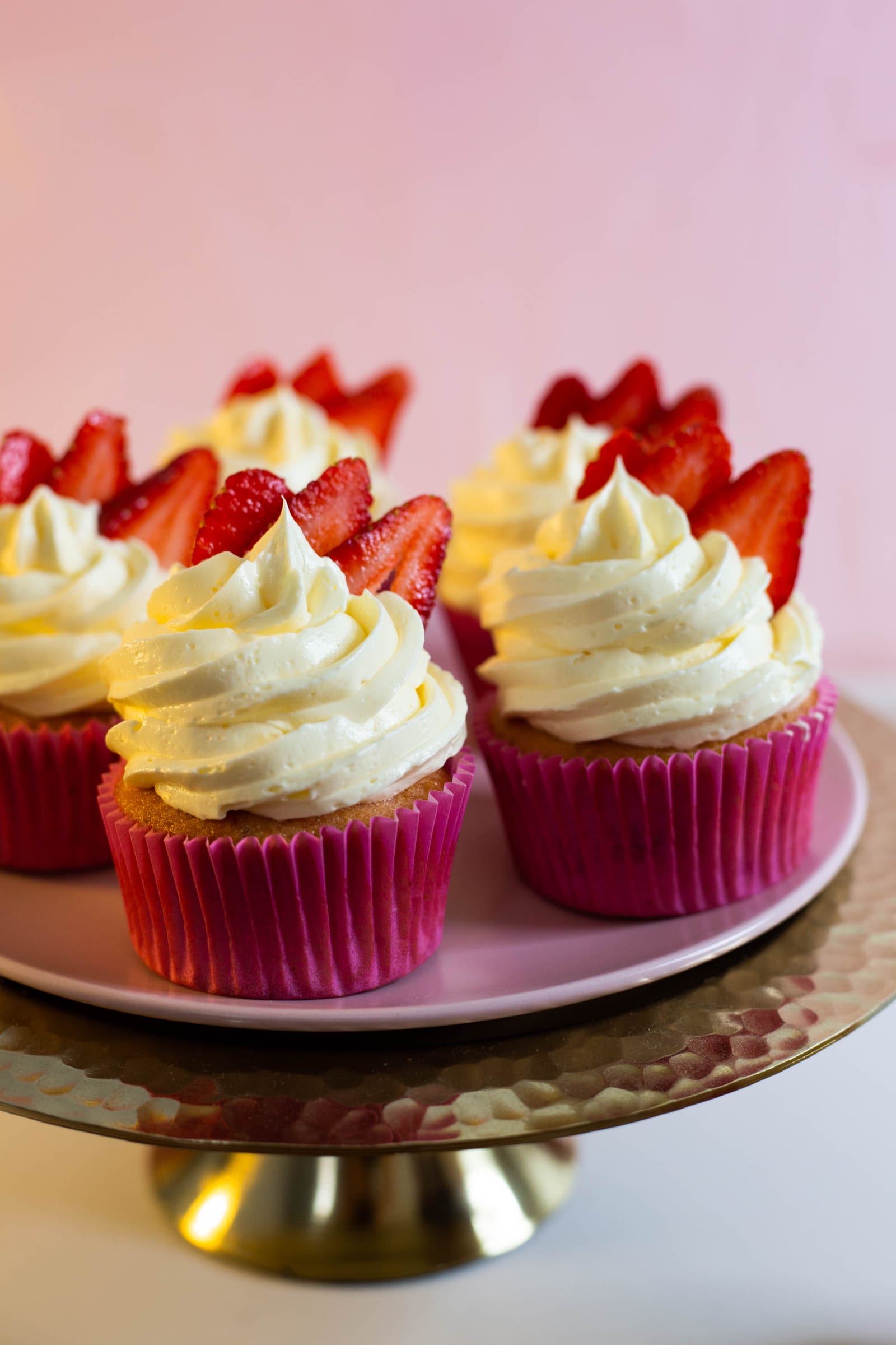 Close-up of strawberry and white chocolate cupcakes on their stand