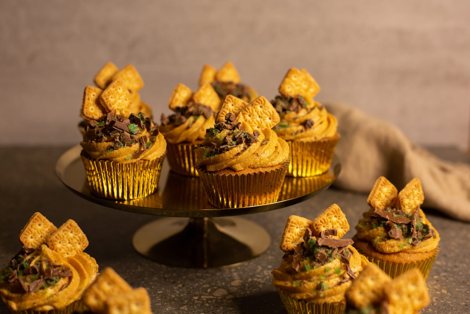 Peppermint crisp tart cupcakes with caramel icing and Tennis biscuits on a gold stand