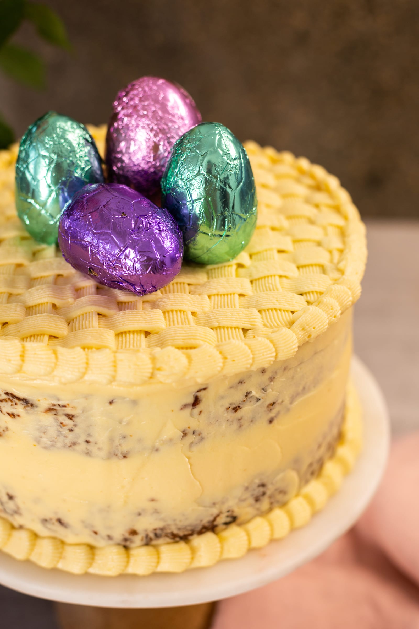 Close-up of the piped frosting and foil Easter eggs on top of a gluten-free carrot cake